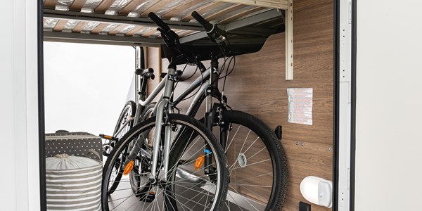 RV rental interior: two bicycles and luggage neatly stored in a dedicated under-bed storage area.. Elnagh BARON 579 2024