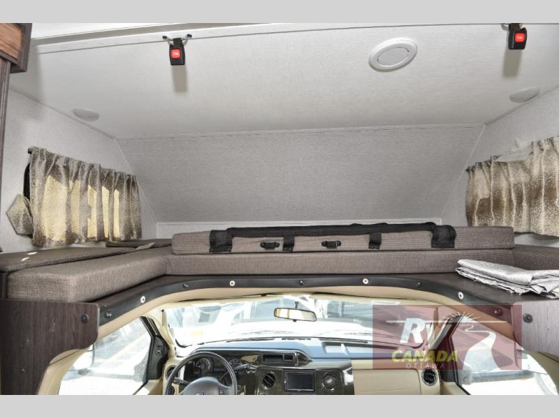 RV rental: Inside a camper, showing the cozy cab-over bunk bed area above the driver's cockpit and dashboard.. Forest River 3011DSF 2019