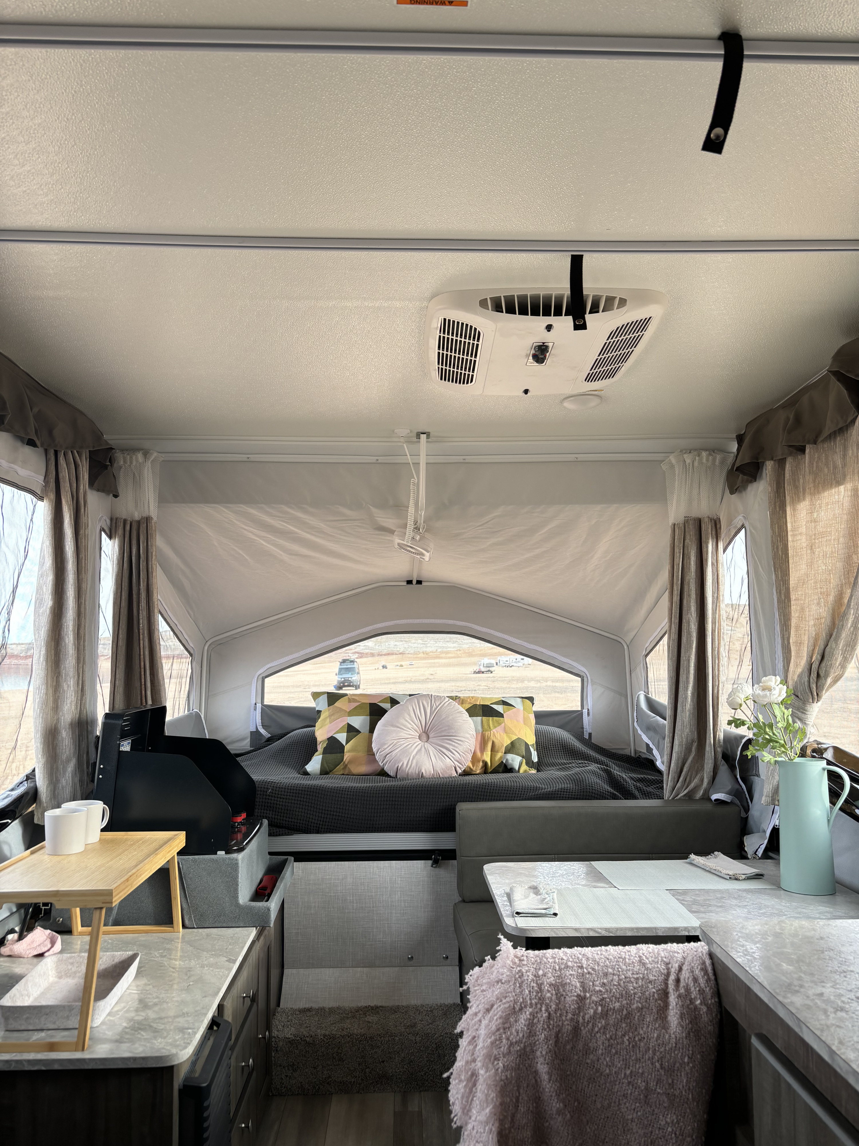 Cozy RV rental interior with a comfy bed, kitchen, and dining area, offering serene views of the outdoors.. Rockwood Freedom 1640LTD 2022