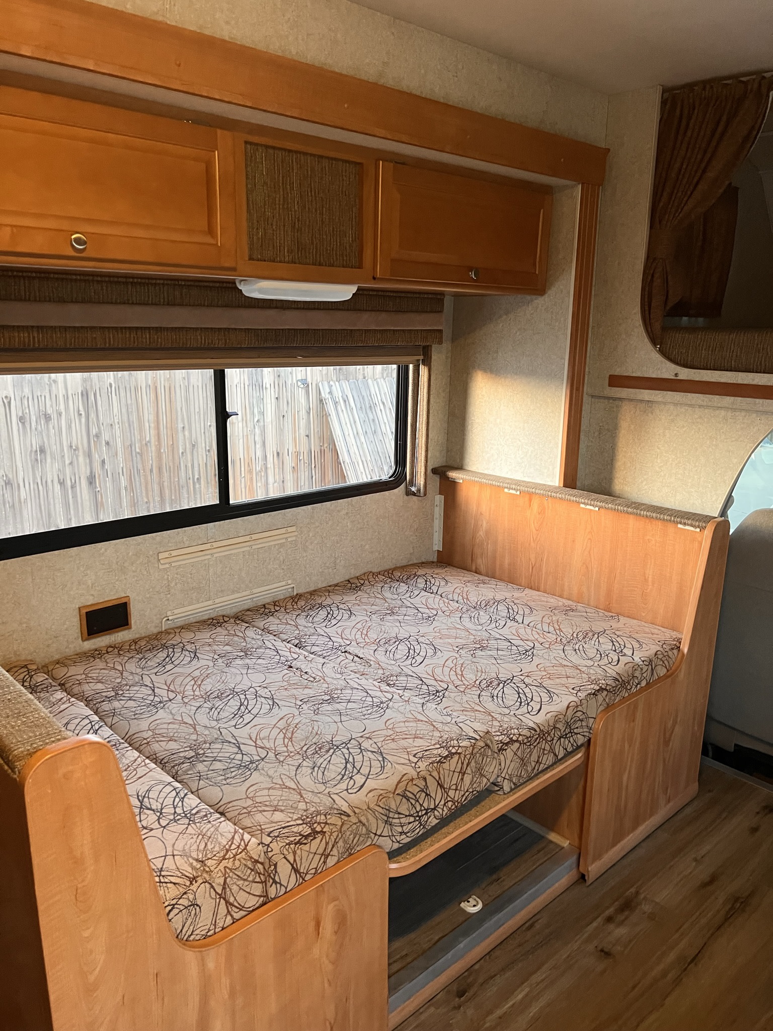 Cozy RV rental interior showing a dinette converted into a bed, ideal for comfortable travel and camping.. Winnebago Access 2008