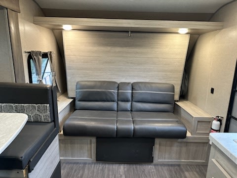 RV rental interior with a convertible sofa/bed, dinette, and windows. This versatile space is ready for your next trip.. Forest River Aurora Aurora 2022