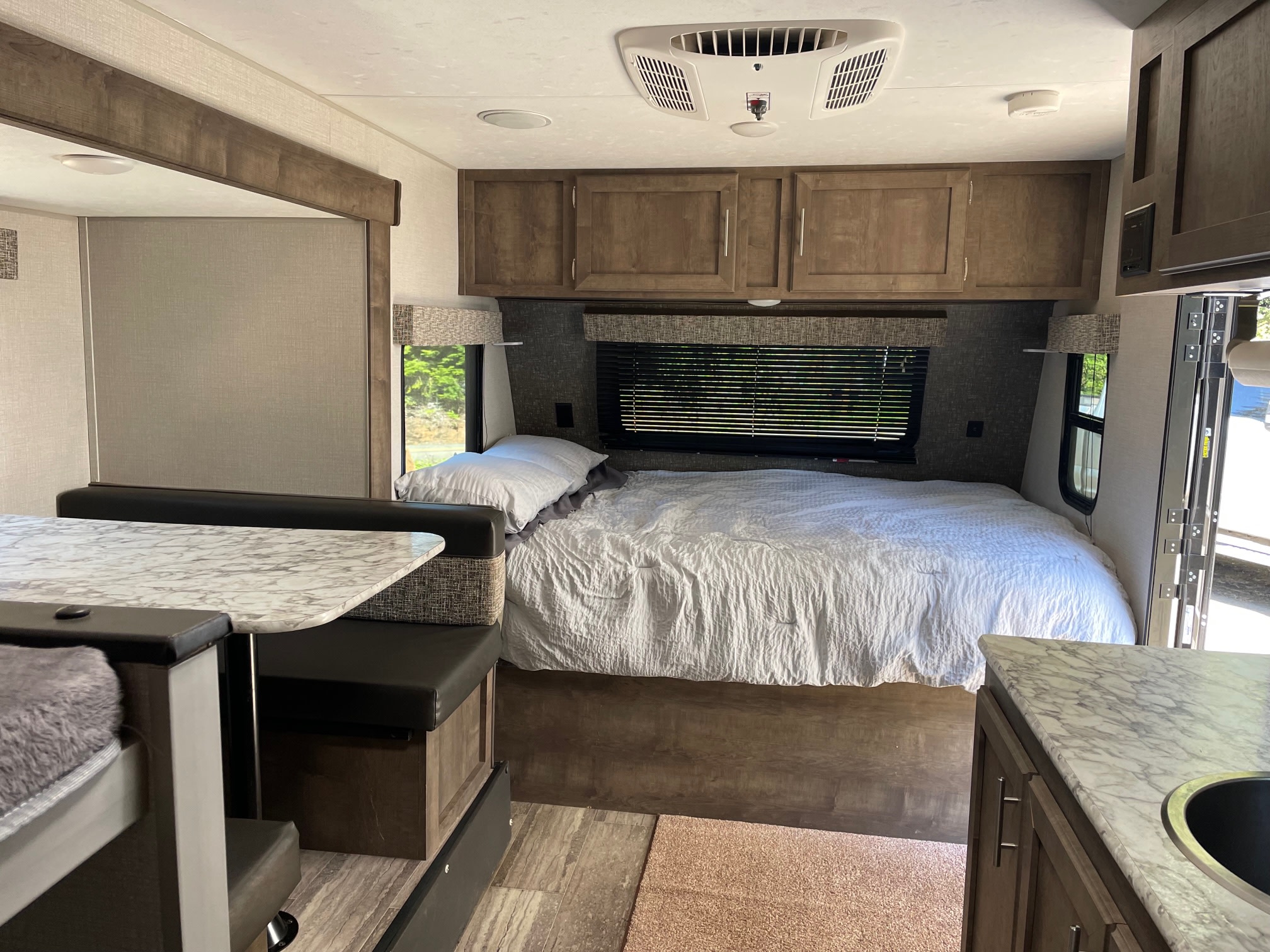 Spacious RV rental interior with a cozy bed, dinette, and kitchen. Perfect for your next adventure!. Sportsmen Classic 2020