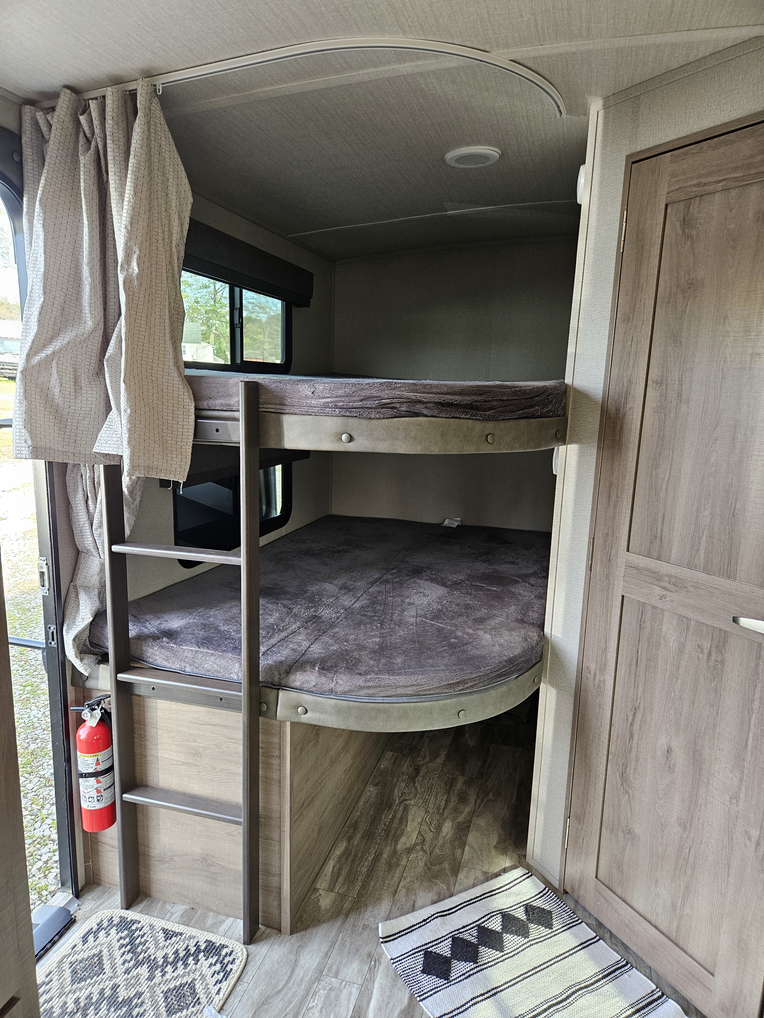 Inside an RV rental: shows bunk beds with ladder, windows, and a fire extinguisher for safe travel.. Grand Design Other 2022