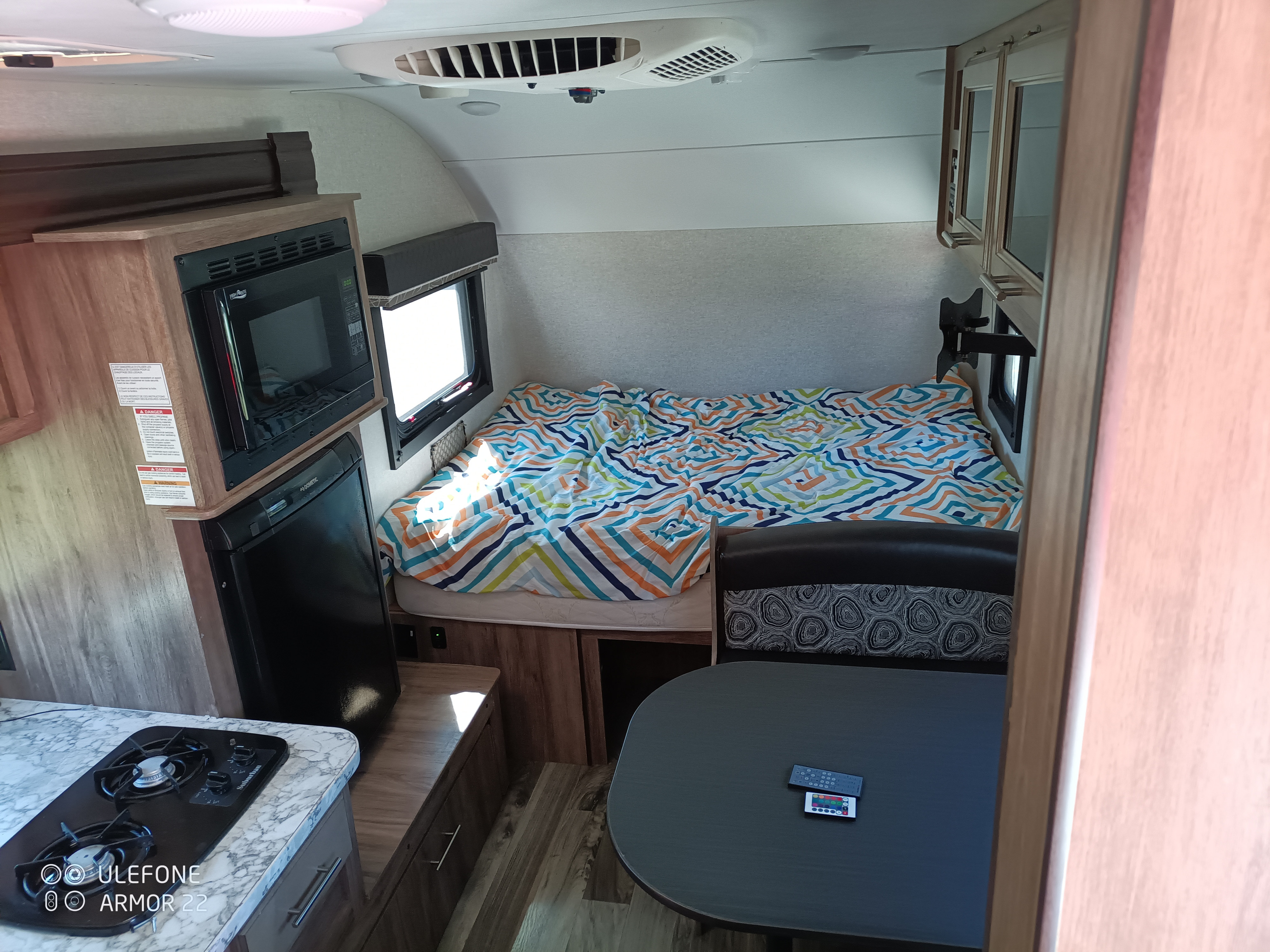 Compact RV interior with a full kitchenette, comfy bed, and dining area, ideal for your next RV rental adventure.. Jayco Hummingbird 2018
