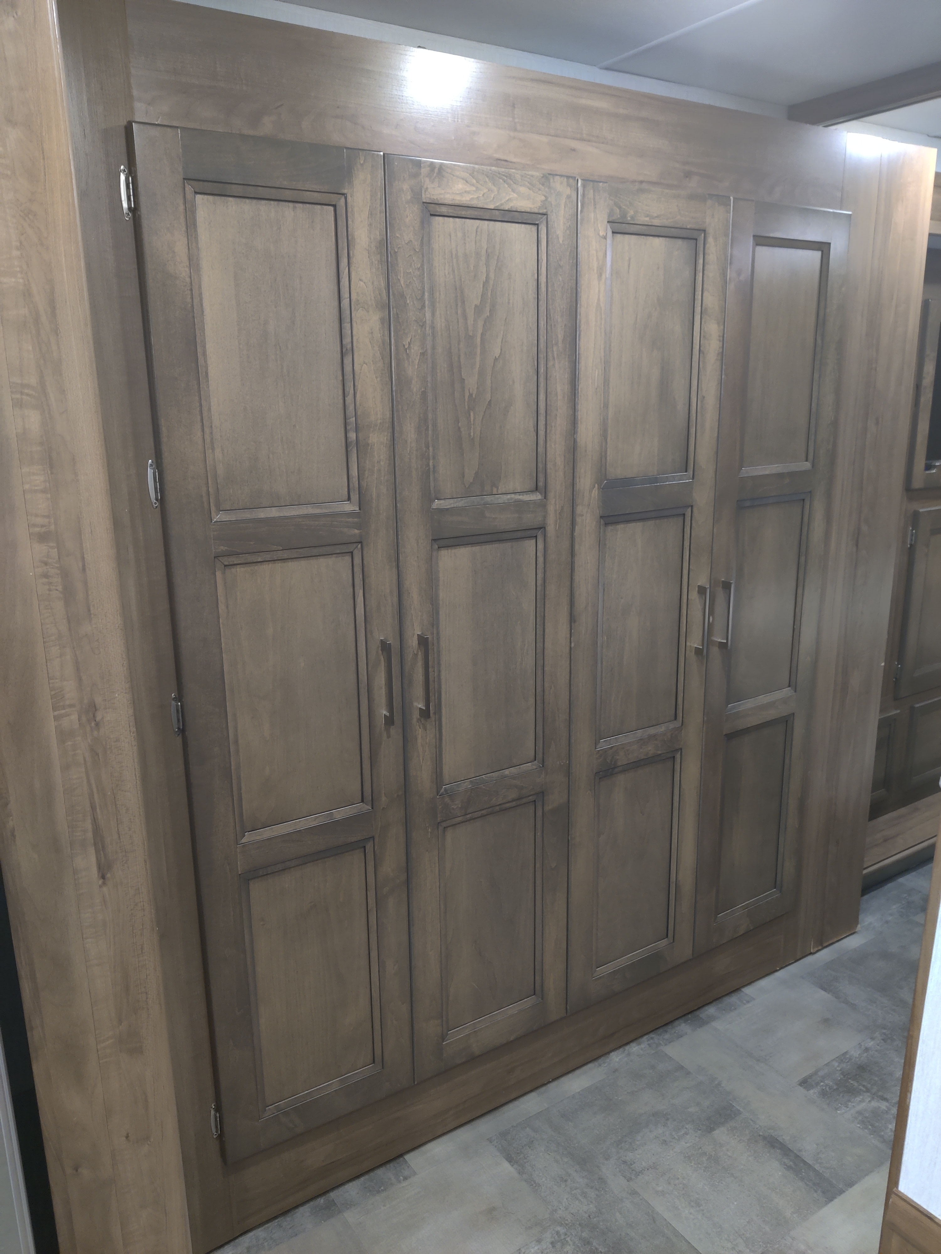 Practical wood wardrobe and cabinet system in this RV rental, offering multi-door storage ideal for compact living spaces.. Forest River Coachmen Mirada 2021
