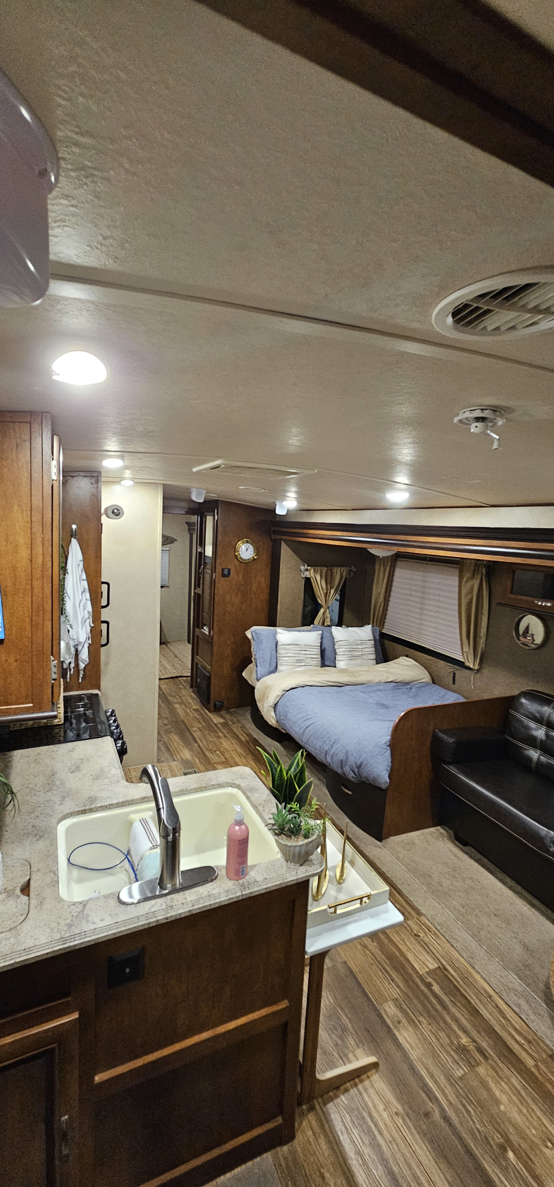 Spacious RV rental interior featuring a well-equipped kitchen, cozy bedroom, and comfortable living area with warm wood details.. Forest River Vibe 2017