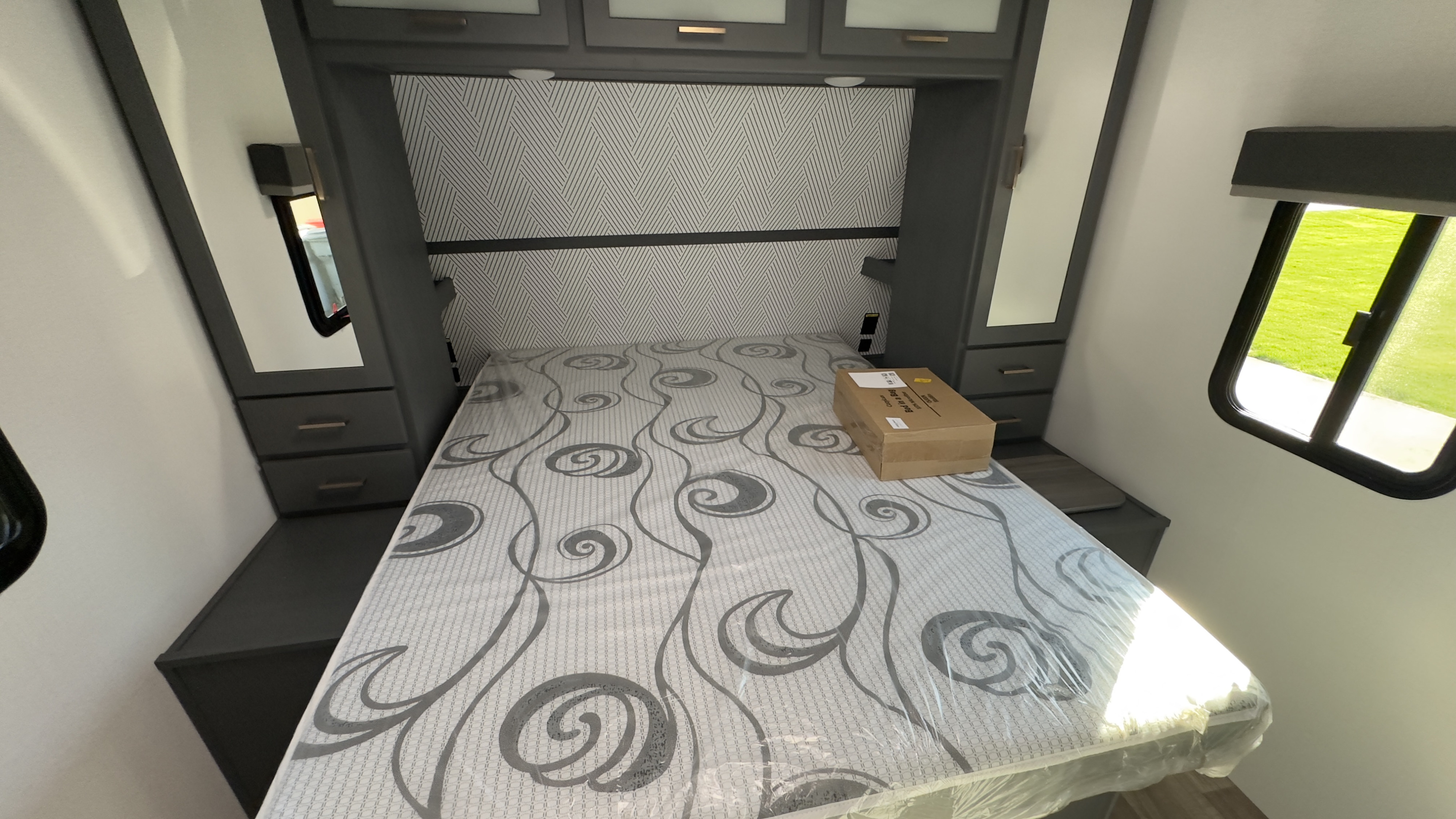 RV rental bedroom: New, plastic-wrapped mattress, built-in storage, and windows, ready for your next journey.. Keystone RV Bullet Premier Ultra Lite 2022