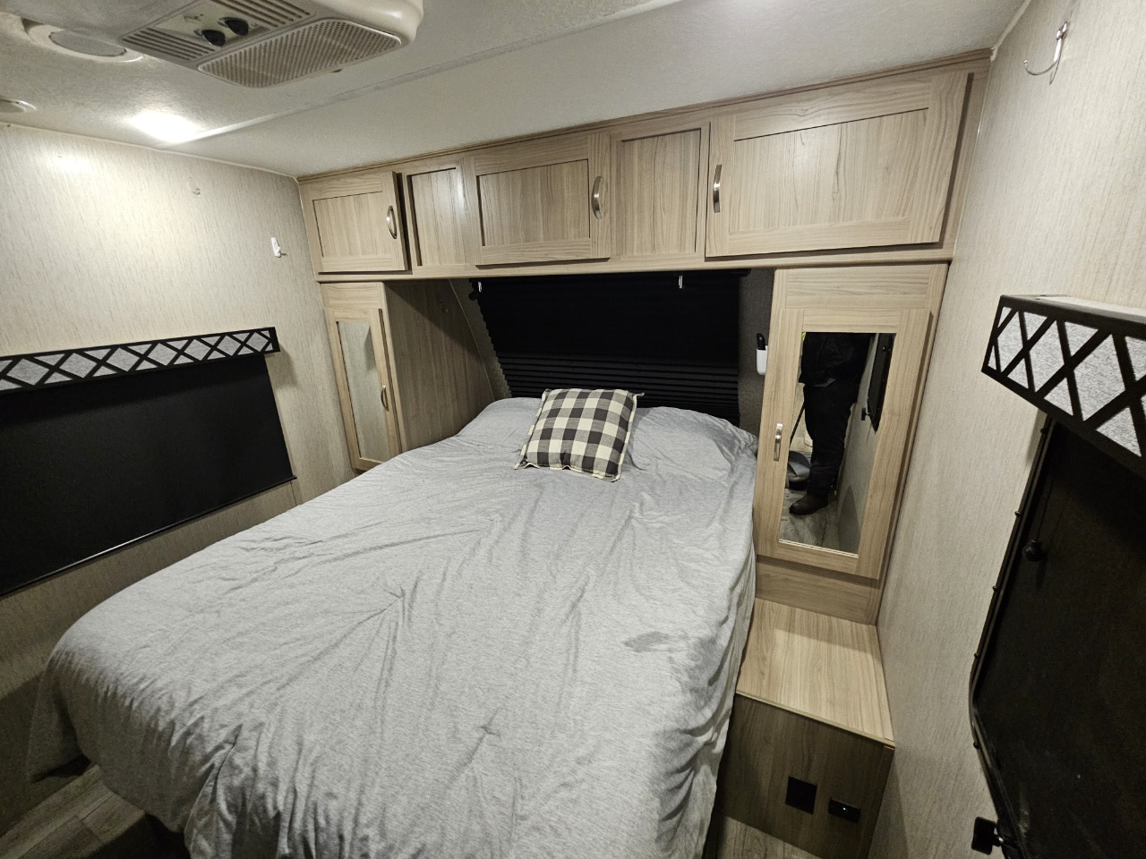 RV rental bedroom with a cozy bed, overhead cabinets, & mirrored wardrobe. Compact, functional travel space.. Coachmen 326BHDSLE 2022