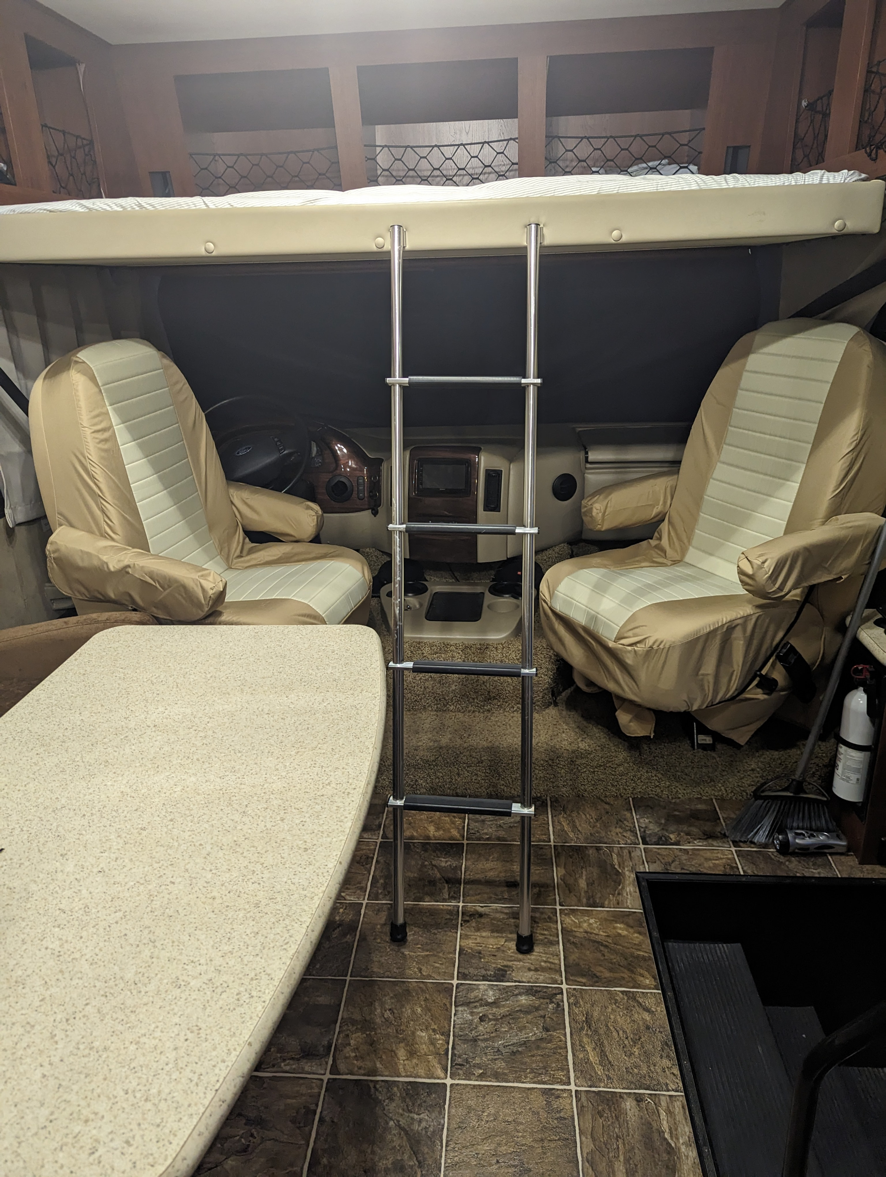 RV rental interior: Cab-over bed, access ladder, and driver's area with covered seats and dinette. Ready for adventure.. Thor Other 2014
