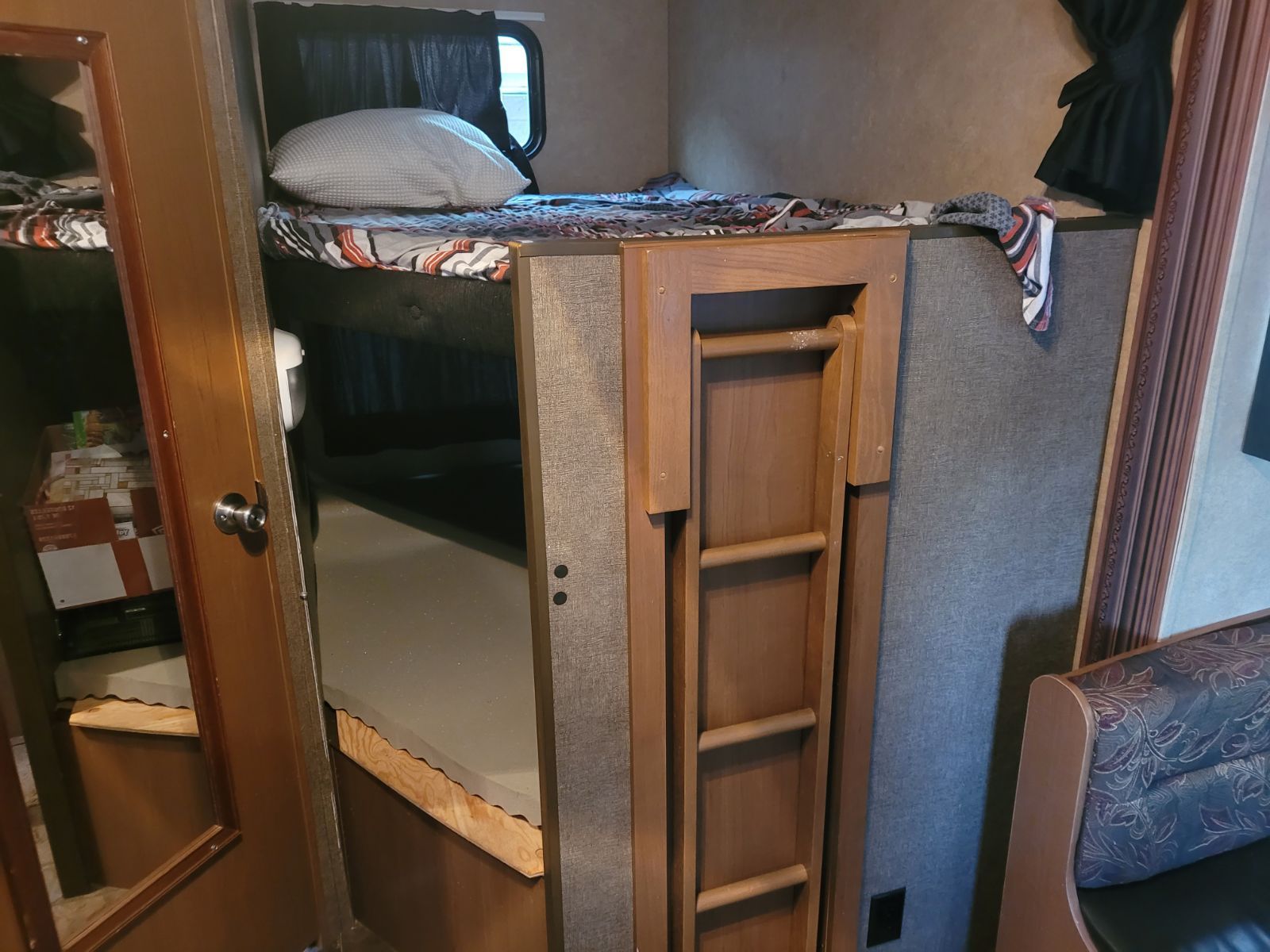 RV rental interior featuring cozy bunk beds with an accessible folded ladder, ideal for family sleeping in a travel trailer.. Starcraft Autumn Ridge 2014
