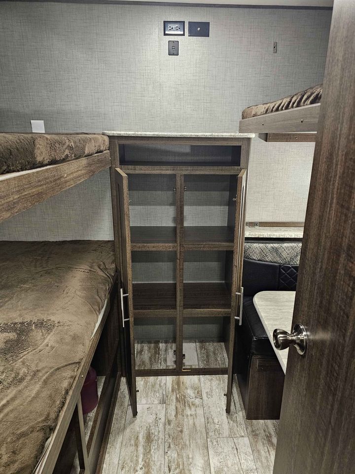 RV rental interior: bunk beds, open central storage unit, and dinette. Efficient, compact living space.. Crossroads Zinger 2018