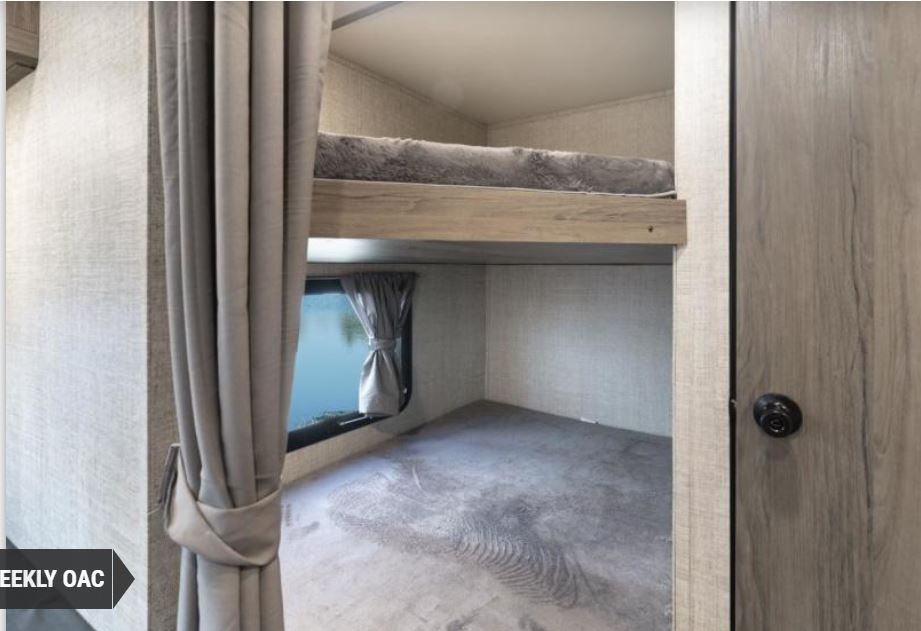 Inside an RV rental: two cozy bunk beds with a window and a privacy curtain, offering comfortable sleeping for your trip.. Gulf Stream Kingsport 2022