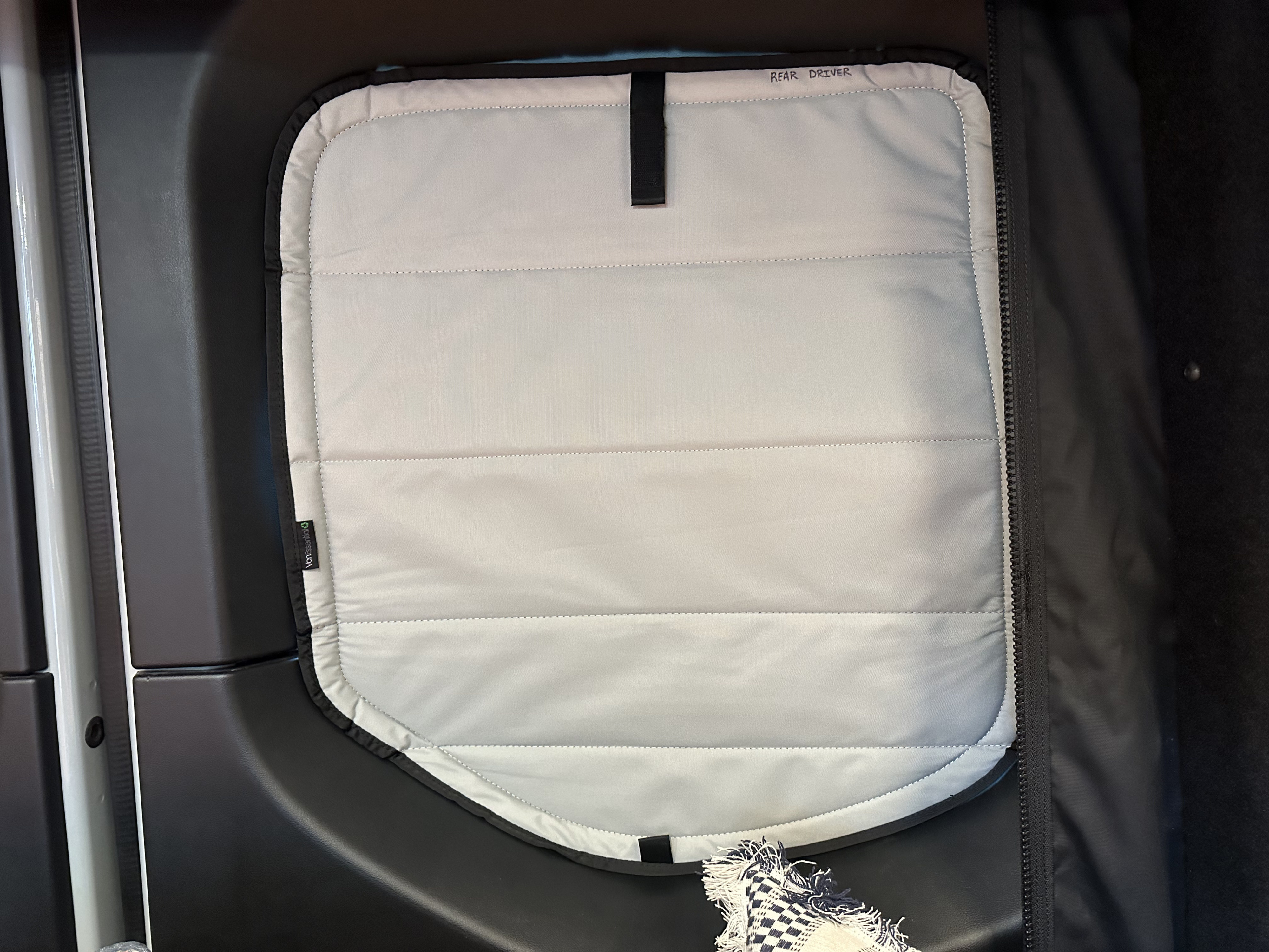 Quilted "REAR DRIVER" window insulation, likely for an RV rental or camper van, improves privacy and climate control.. Mercedes-Benz Sprinter 2023