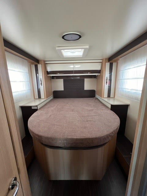 Cozy RV rental bedroom with spacious bed, overhead storage, and natural light from skylight, ideal for travel.. McLOUIS PEUGEOT 279 2024