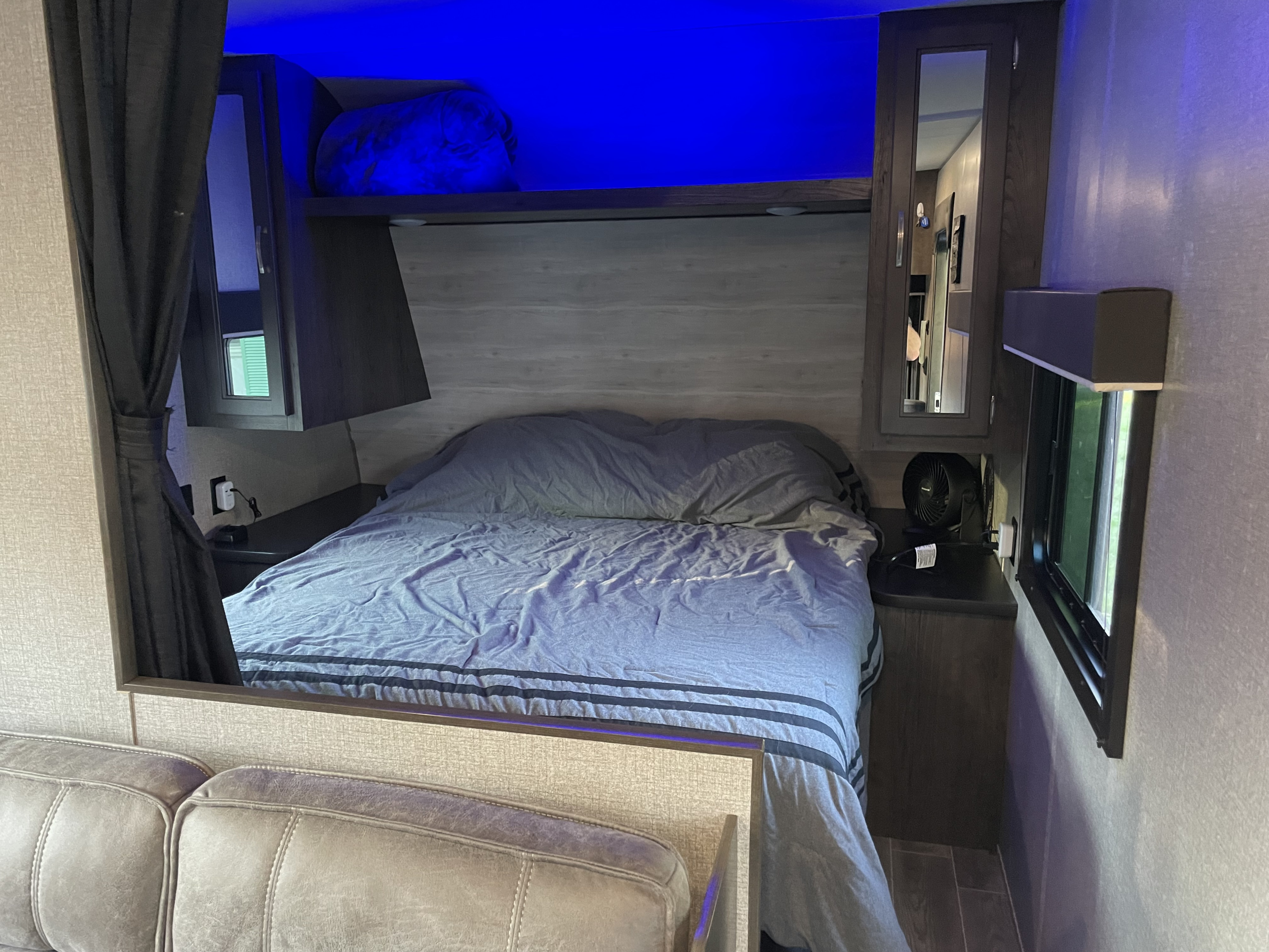 Cozy RV rental bedroom with a comfy bed, integrated storage, and ambient blue LED lighting.. Jayco Jay Flight SLX 2021