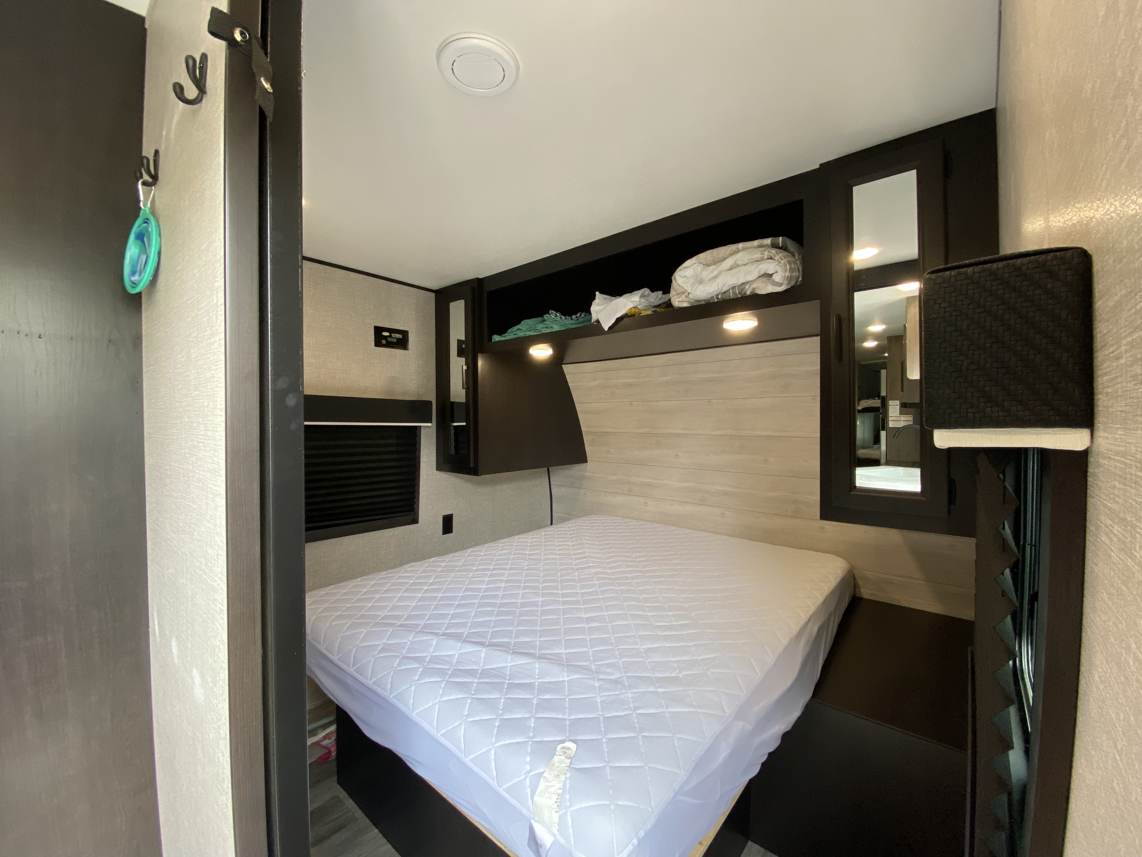 Cozy RV rental bedroom features a comfortable bed, smart overhead storage, and modern finishes for a relaxing stay.. Jayco Jay Flight 2023