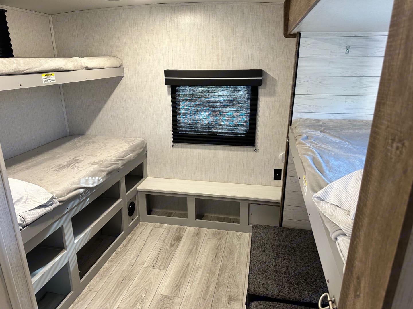 Bright RV rental interior with multiple bunk beds, a window, and built-in storage. Great for group travel.. Heartland RVs North Trail 2022
