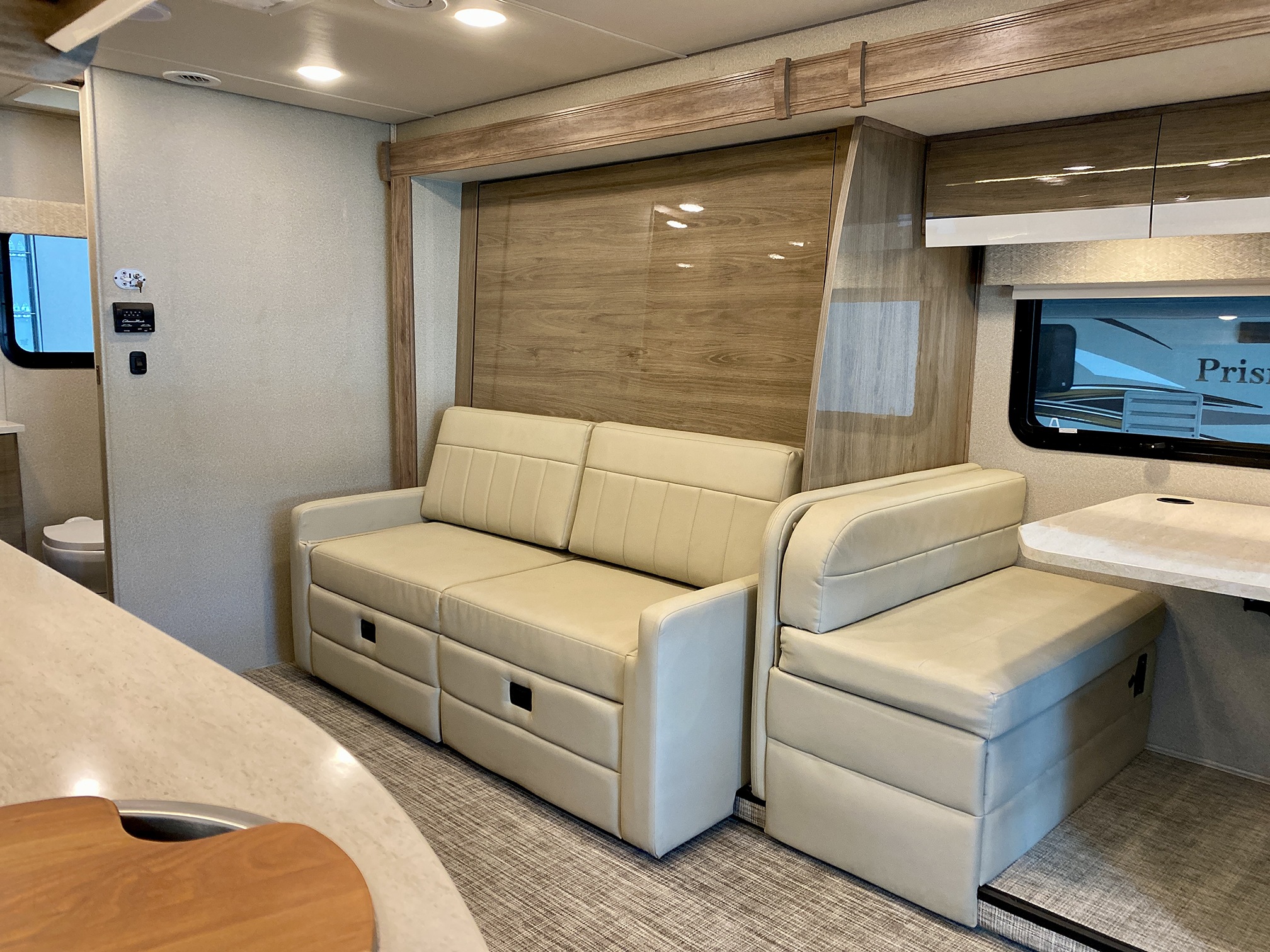 RV rental interior featuring a light-colored pull-out sofa, dinette, and compact kitchen area.. Entegra Coach Qwest 2020