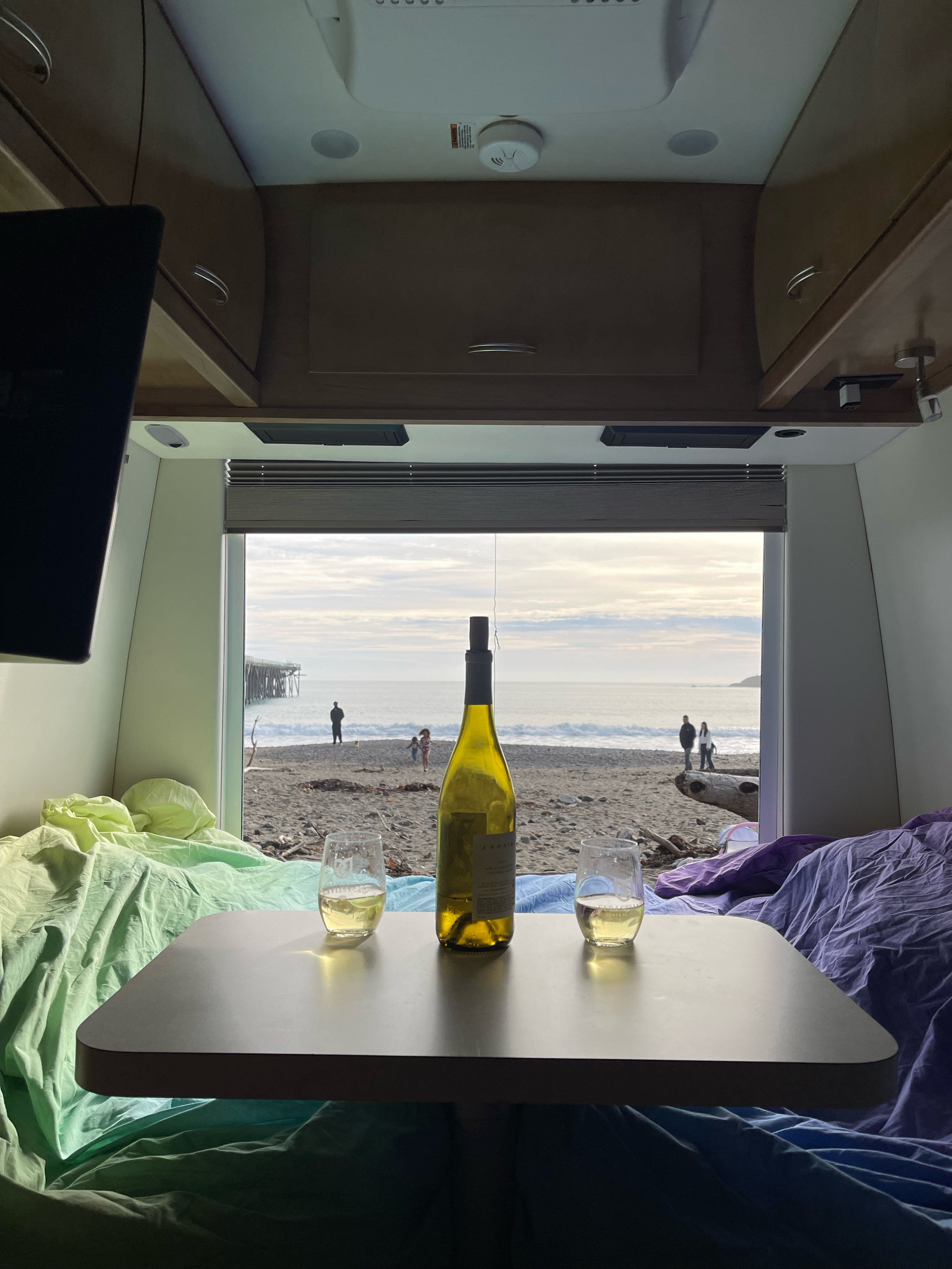 Enjoying the ultimate RV rental experience: wine with a stunning beach and ocean view from inside the camper.. Mercedes Benz Sprinter 2018