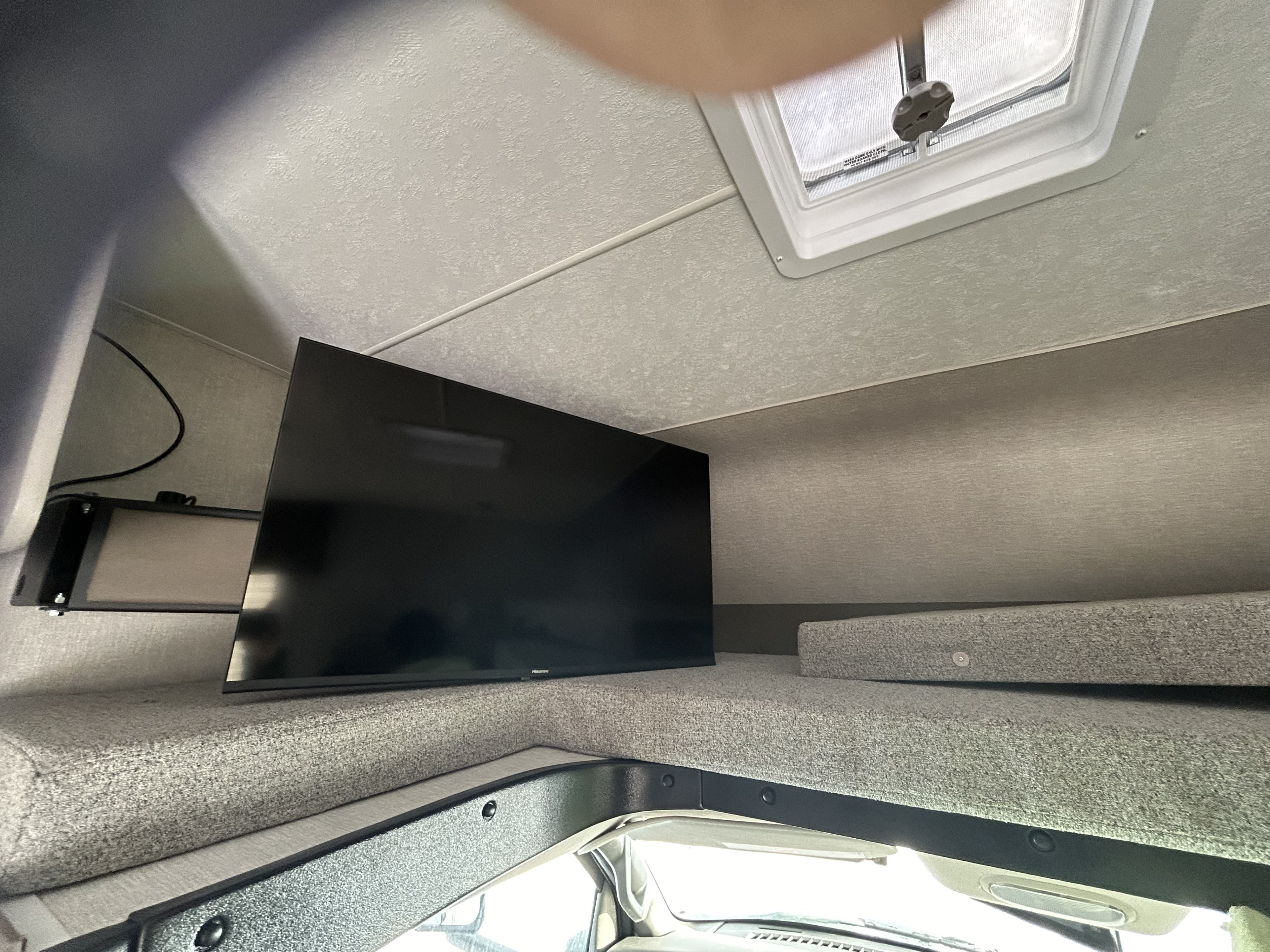 RV rental interior: Overhead bunk with a mounted TV, offering a cozy sleeping area in this camper.. Forest River Freelander 2024
