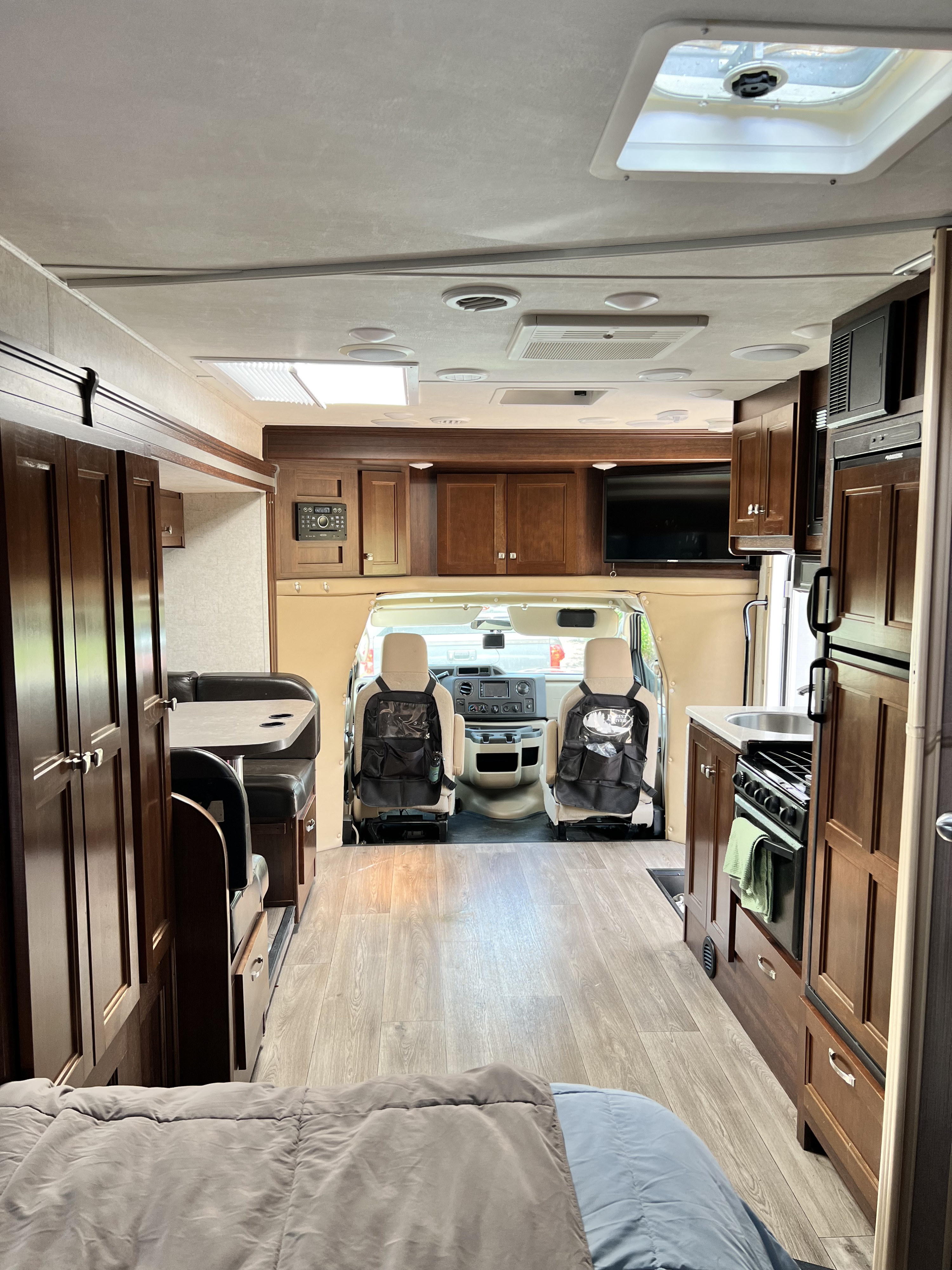 Interior of an rv rental, featuring a compact kitchen, dinette, and driver's cab view, perfect for road trip adventures.. Forester GTS 2018