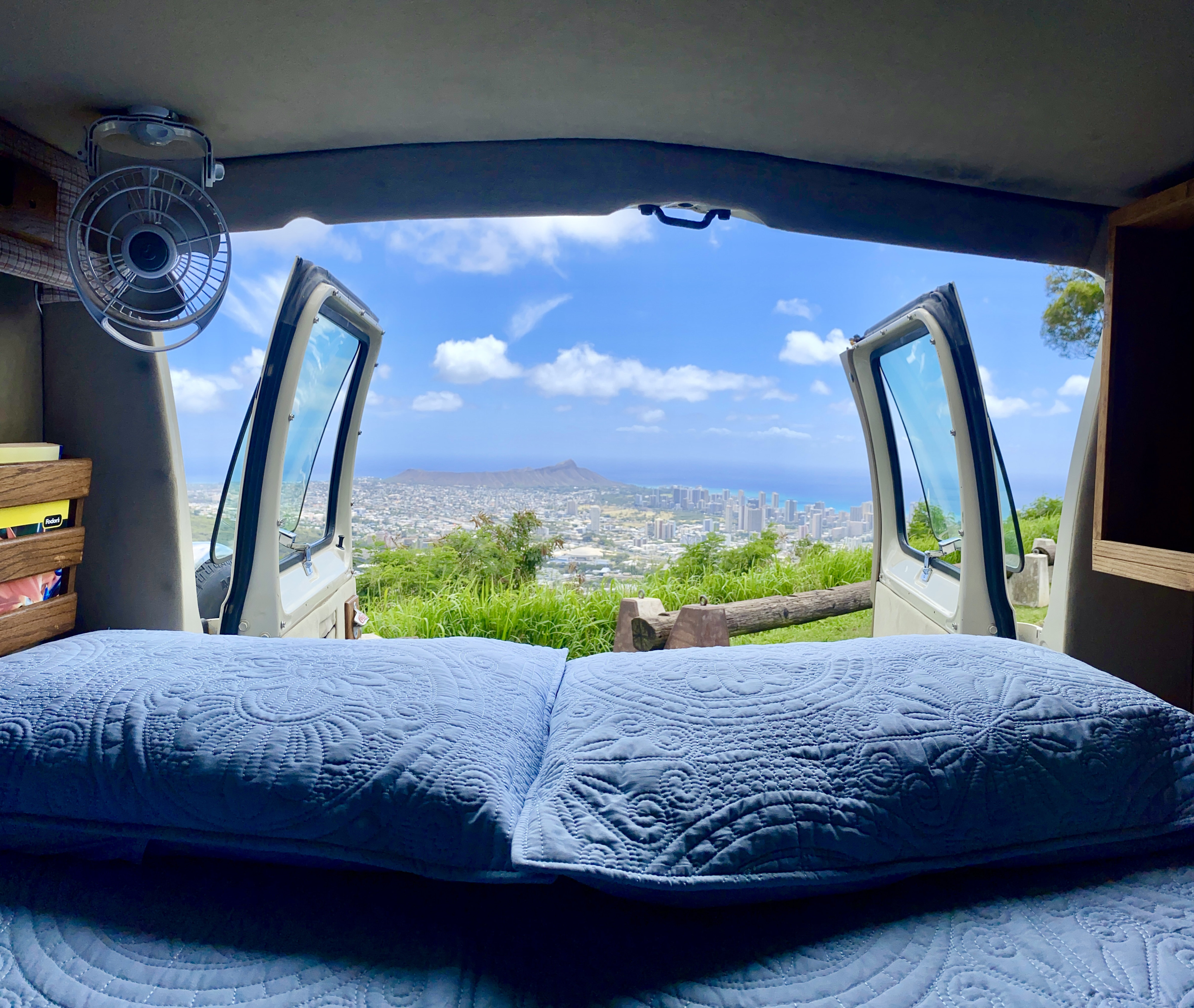 Comfortable RV rental bed with open doors revealing a stunning panoramic city, mountain, and ocean view.. Dodge 230-515 1993