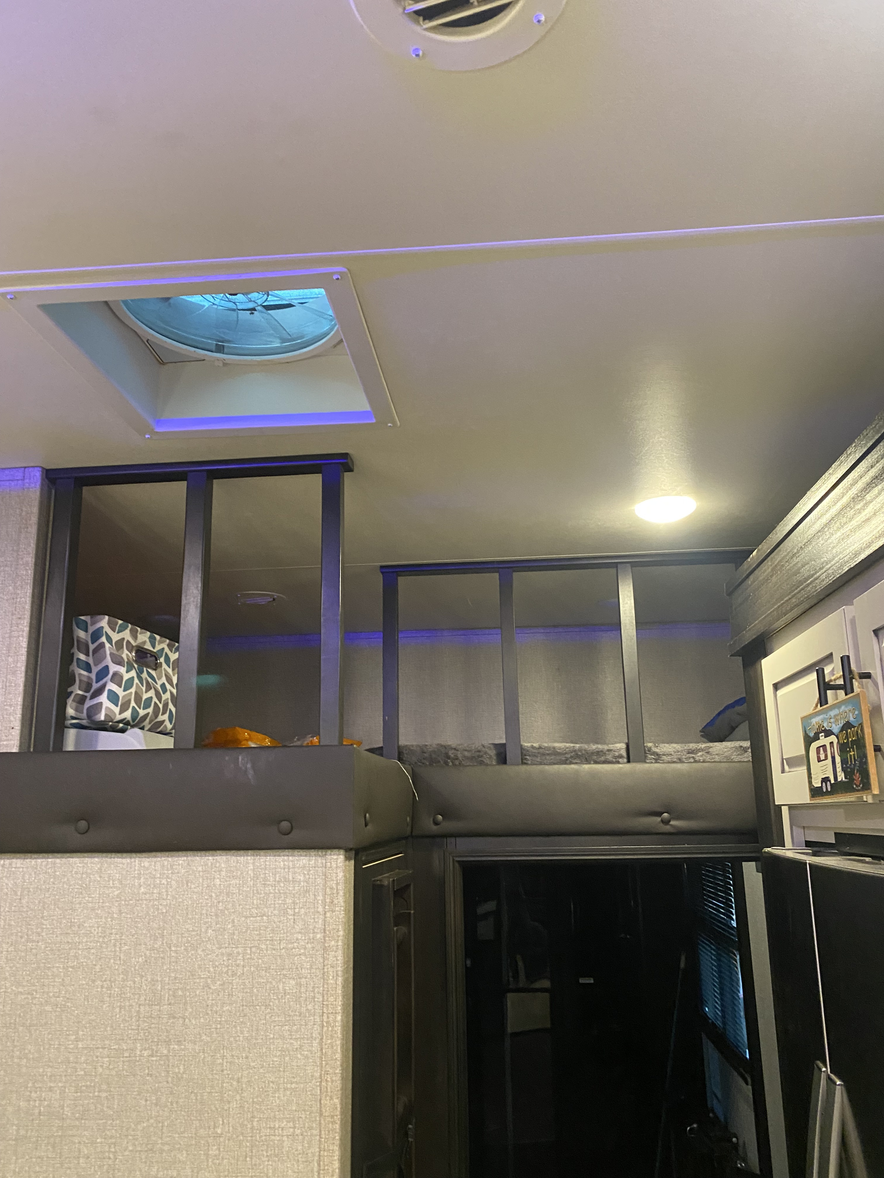 View inside an RV rental showing stacked bunks, ceiling vent, and blue ambient lighting.. Jayco Seismic Toy Hauler 2020