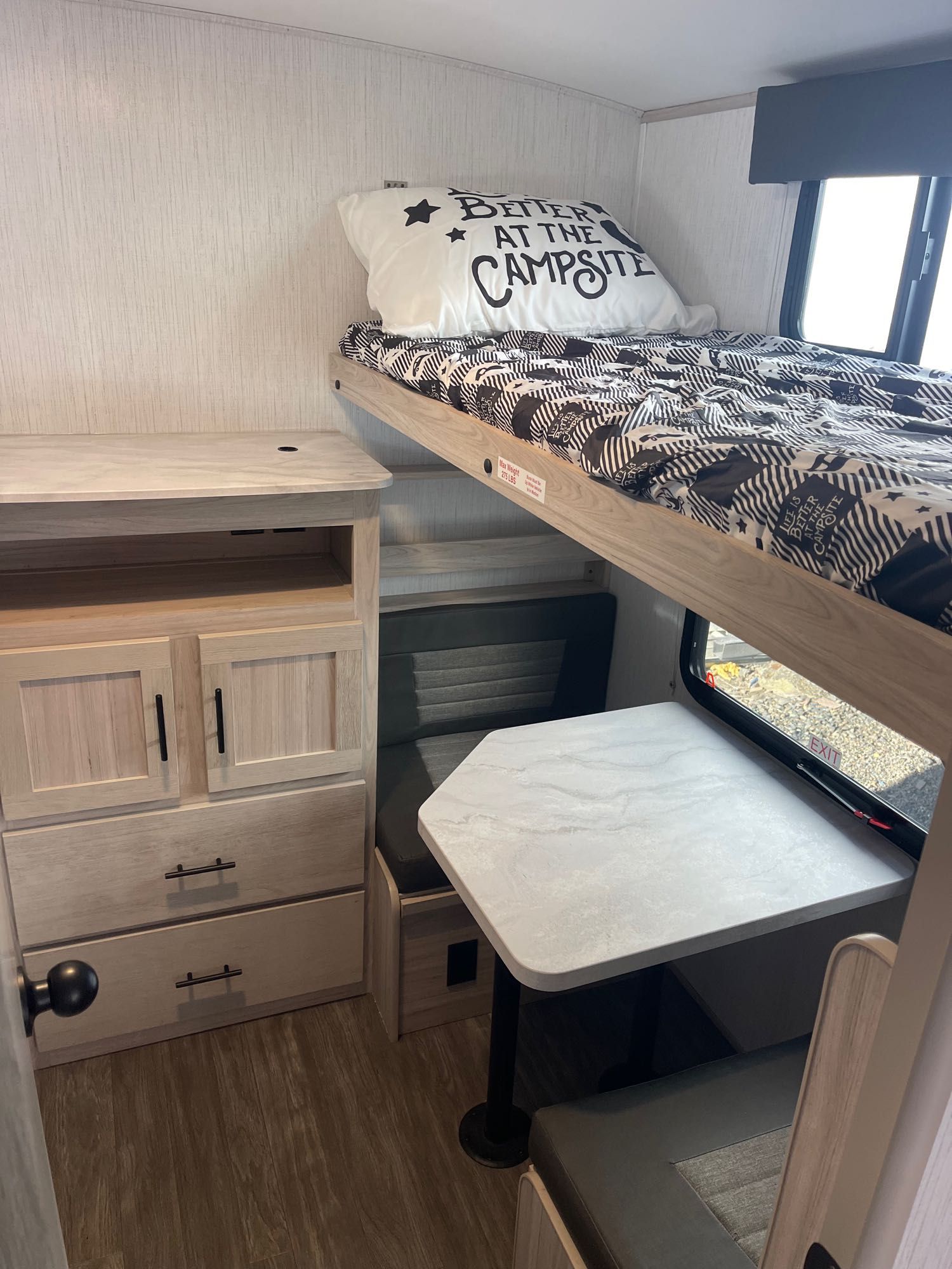 An RV rental showing a light wood interior with a bunk bed, dinette, and cabinet storage.. Cruiser RV Shadow Cruiser 2023