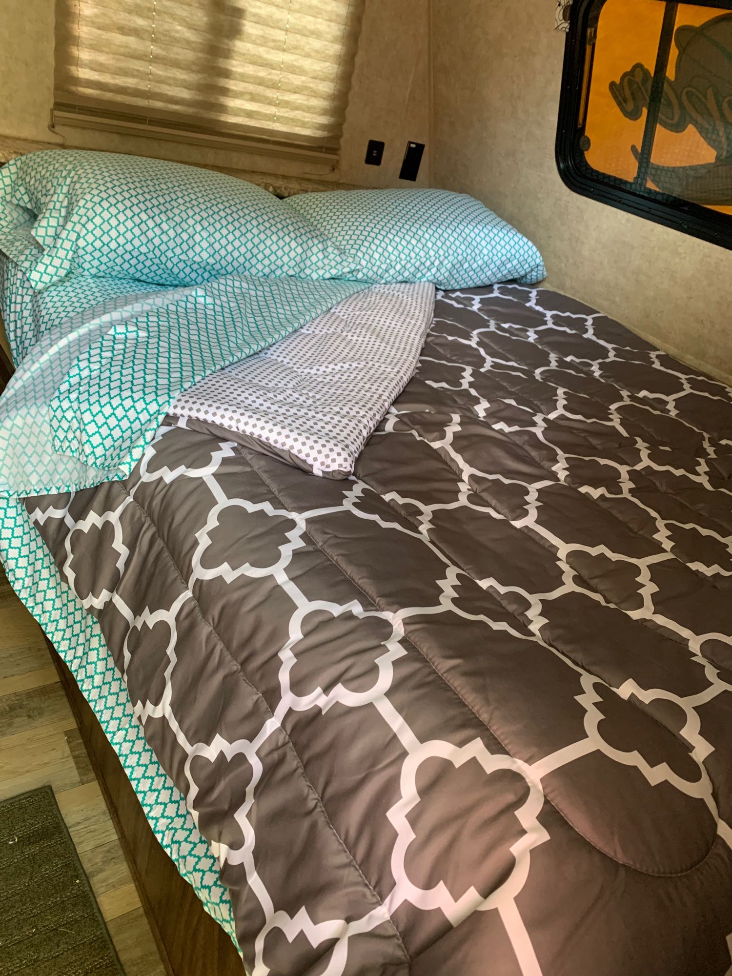 Inviting RV rental bed: Teal sheets, patterned comforter & pillows, ready for cozy travel in your RV.. Coachmen Clipper 2017