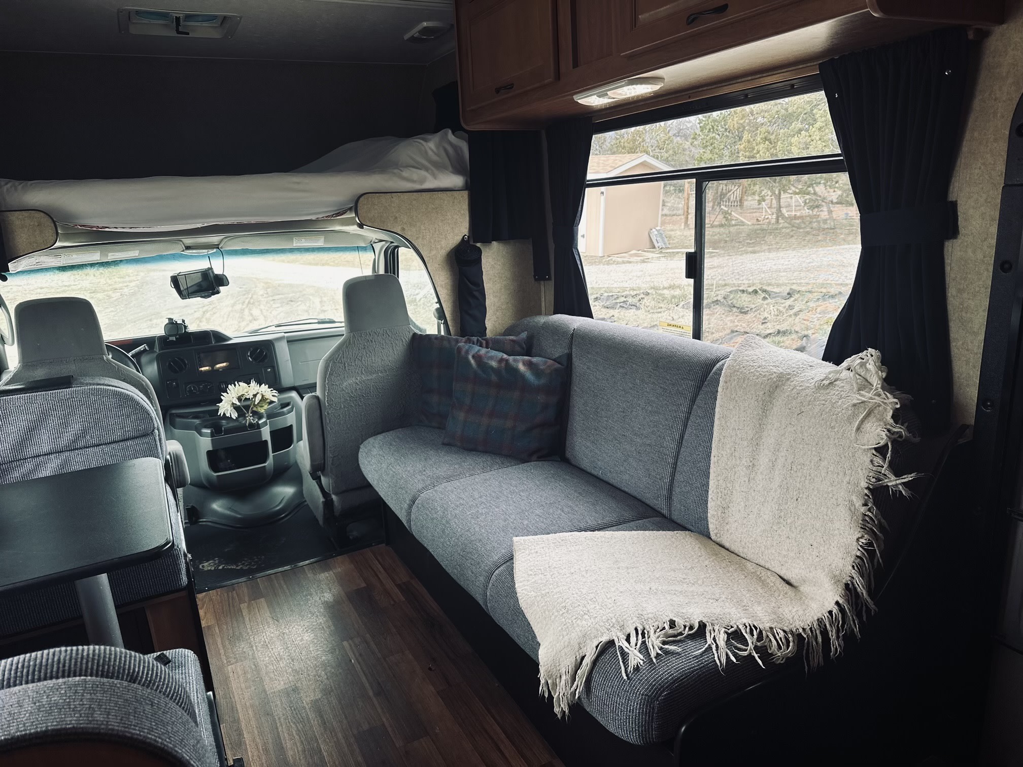 Step inside this inviting RV rental, featuring a spacious sofa, bed above the cab, and a functional interior for your next adventure.. Thor Majestic 2016