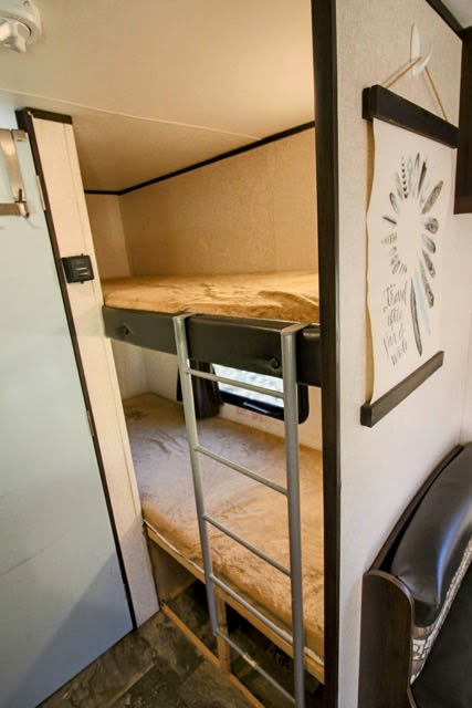 Inside an RV rental: built-in bunk beds with ladder and mattresses, offering cozy sleeping space for travelers.. Jayco Jay Flight SLX 2017