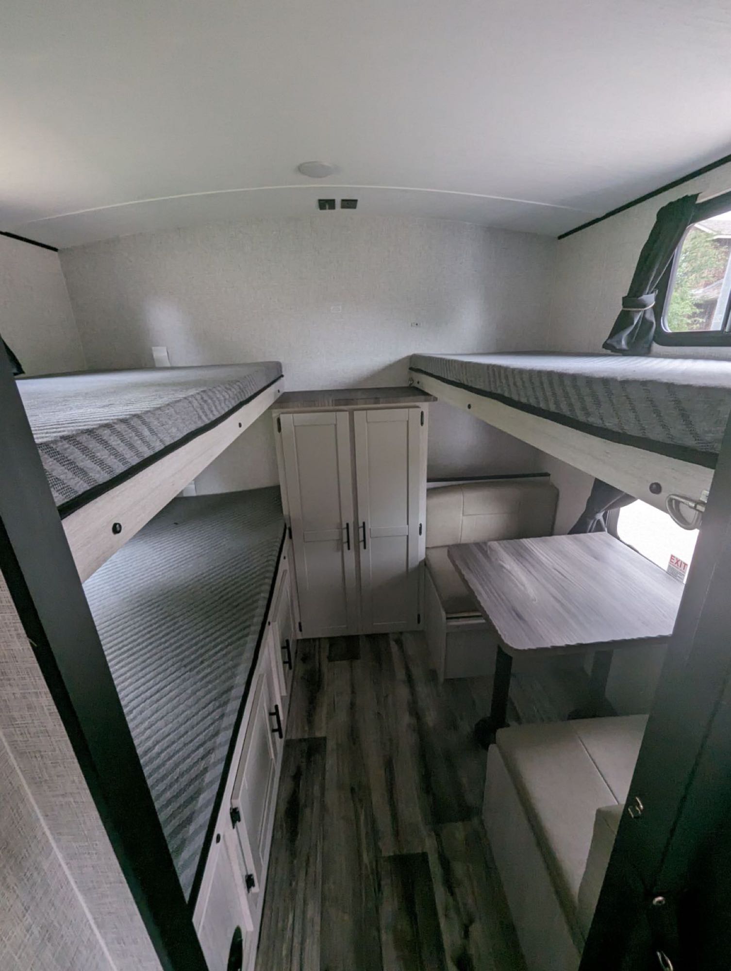 Inside an RV rental, showing a cozy dinette, ample storage, and comfortable bunk beds, ideal for families traveling.. Crossroads RV Sunset Trail Superlite 2024
