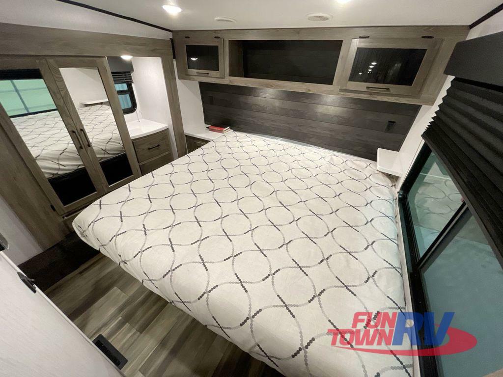 Experience comfort in this RV rental bedroom, featuring a queen bed, mirrored closet, and overhead storage.. Heartland RVs Gravity Toy Hauler 2022
