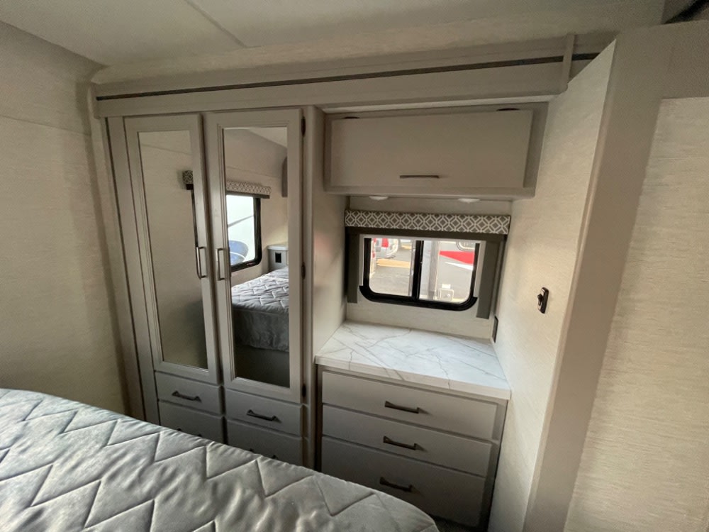 RV rental: well-appointed bedroom with mirrored closet, dresser, window, and ample storage. Perfect for travel.. Thor Coleman 2023