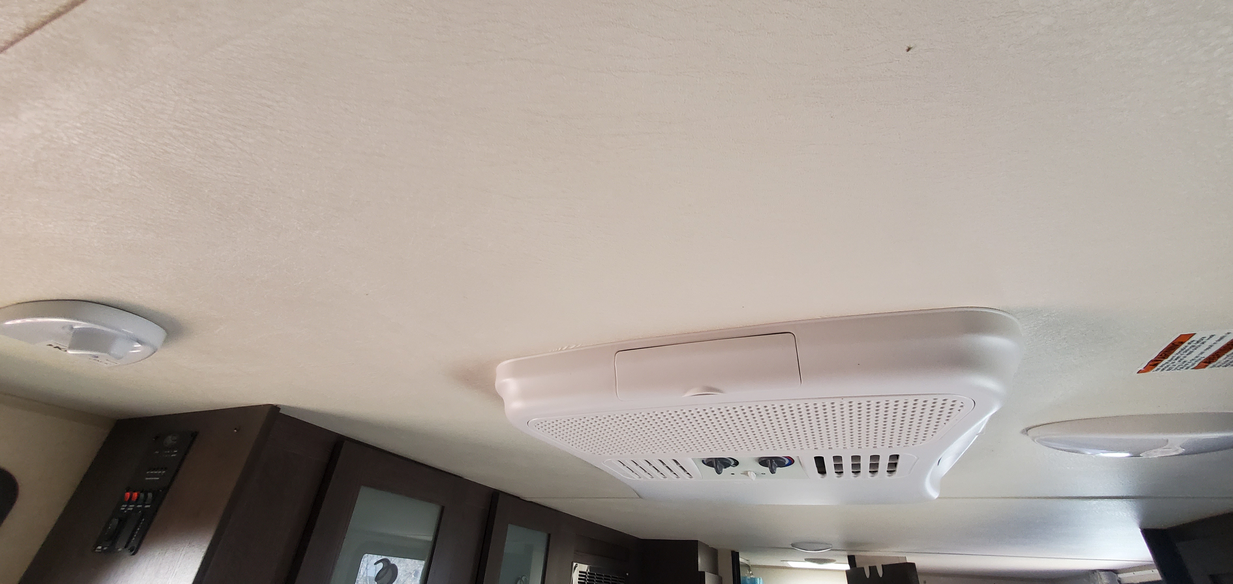 RV rental interior ceiling shows a white AC unit, smoke detector, light, and control panel above cabinets.. Forest River Salem FSX 2019