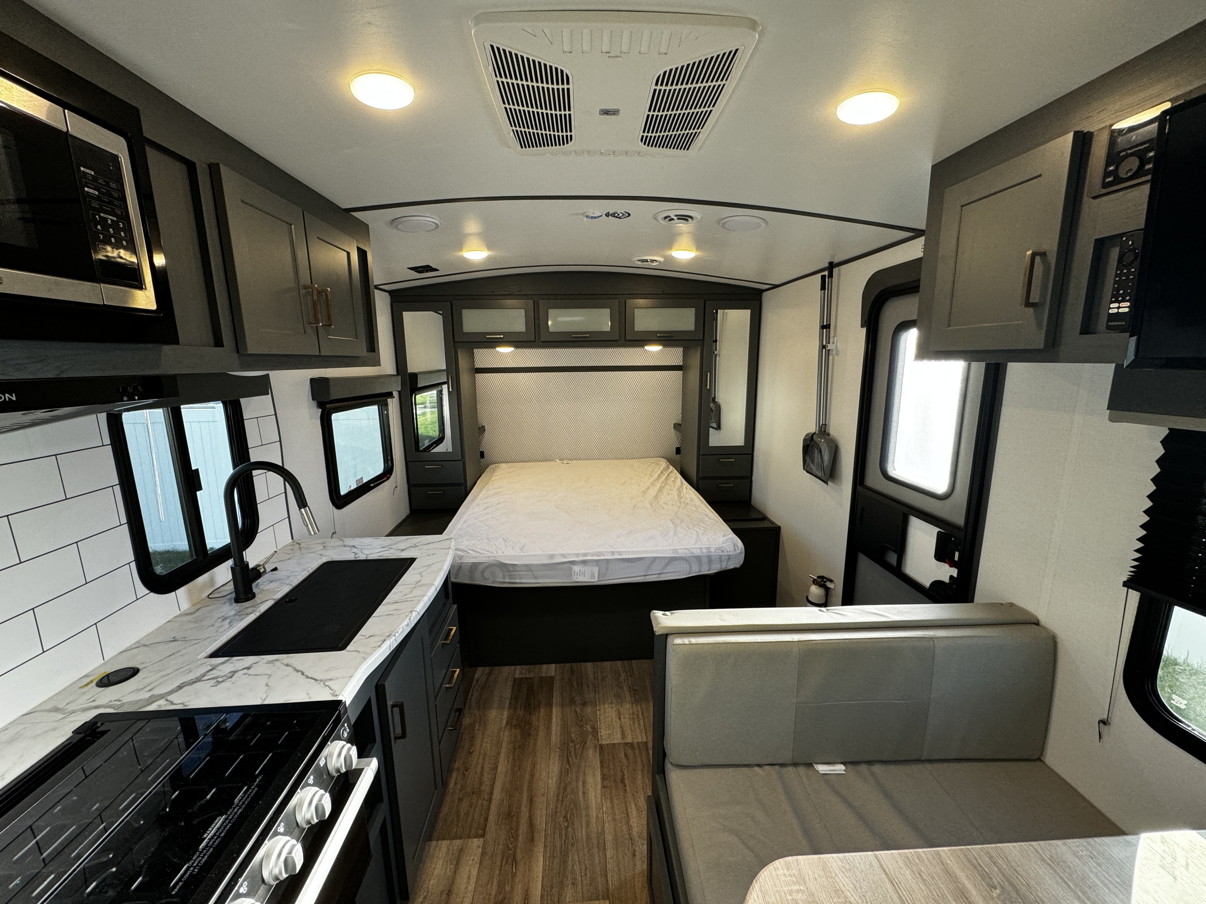 Explore this modern RV rental interior! Featuring a full kitchen, comfortable bed, and spacious dinette for your travels.. Keystone RV Bullet Ultra Lite 2023