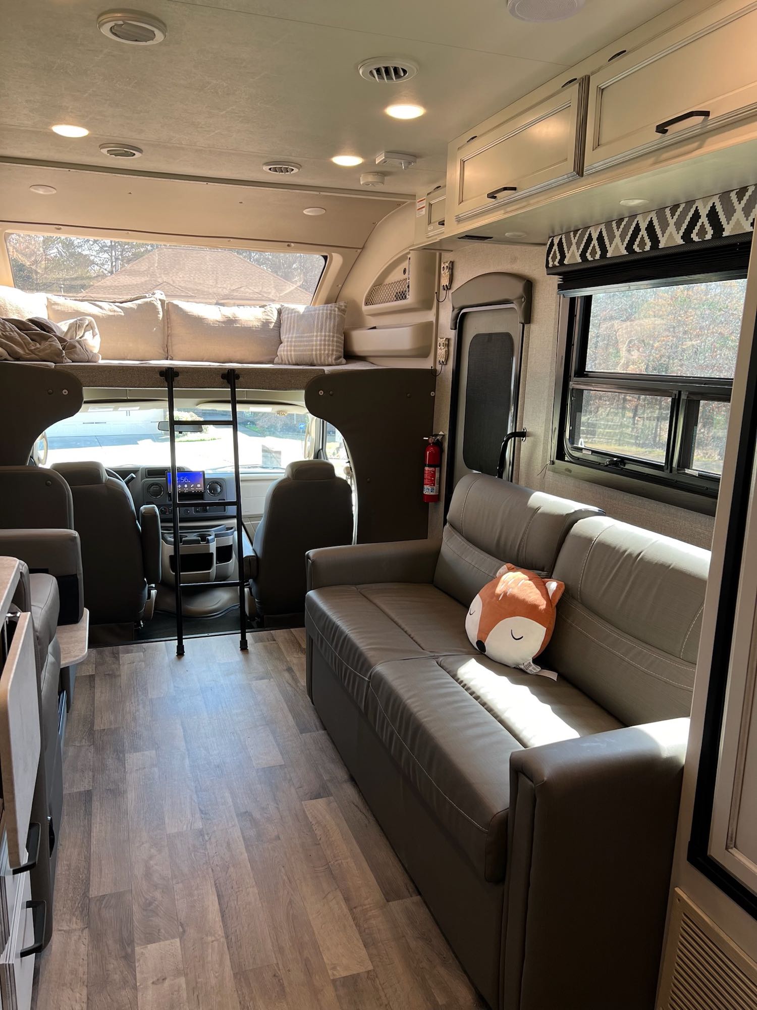 Spacious RV rental interior with bunk bed, sofa, modern finishes & cockpit view.. Entegra Coach Odyssey 2021