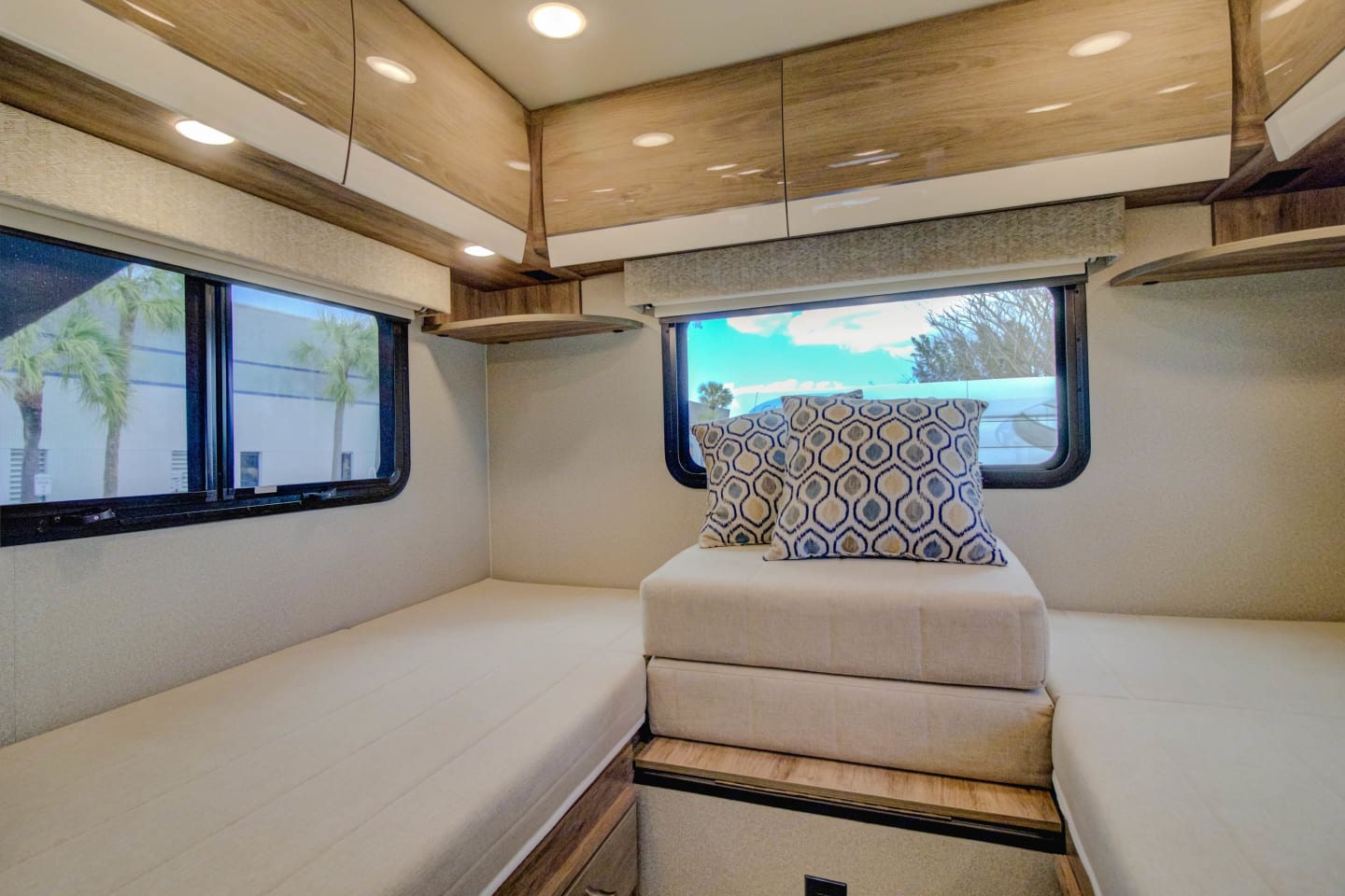 Spacious RV rental interior with flexible seating, convertible beds, overhead cabinets, and large windows.. Entegra Coach Qwest 2020