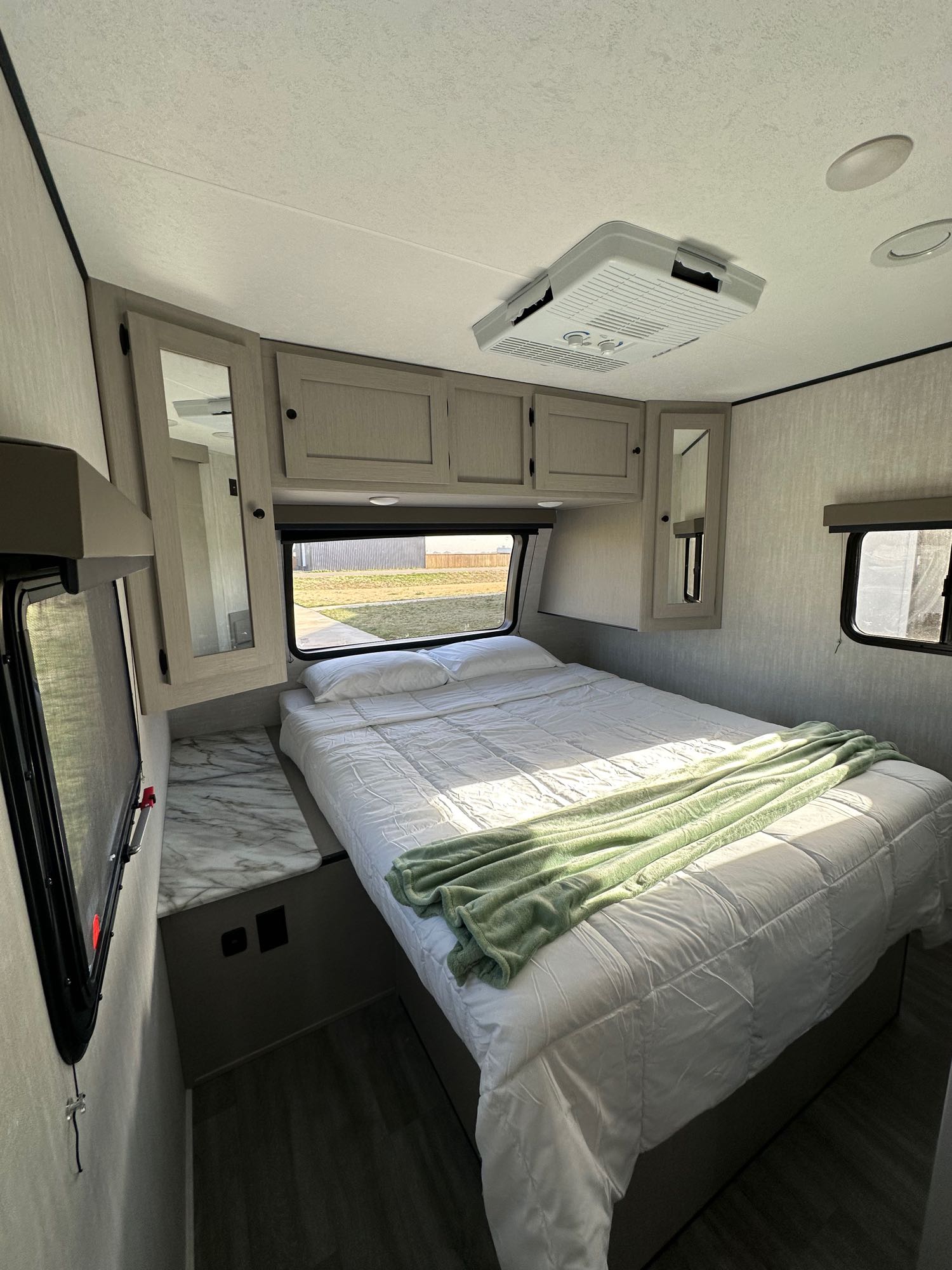 Cozy RV rental bedroom with a comfy bed, overhead storage, windows, and AC unit.. Forest River Coachmen Apex UtlraLite 284BHSS 2024