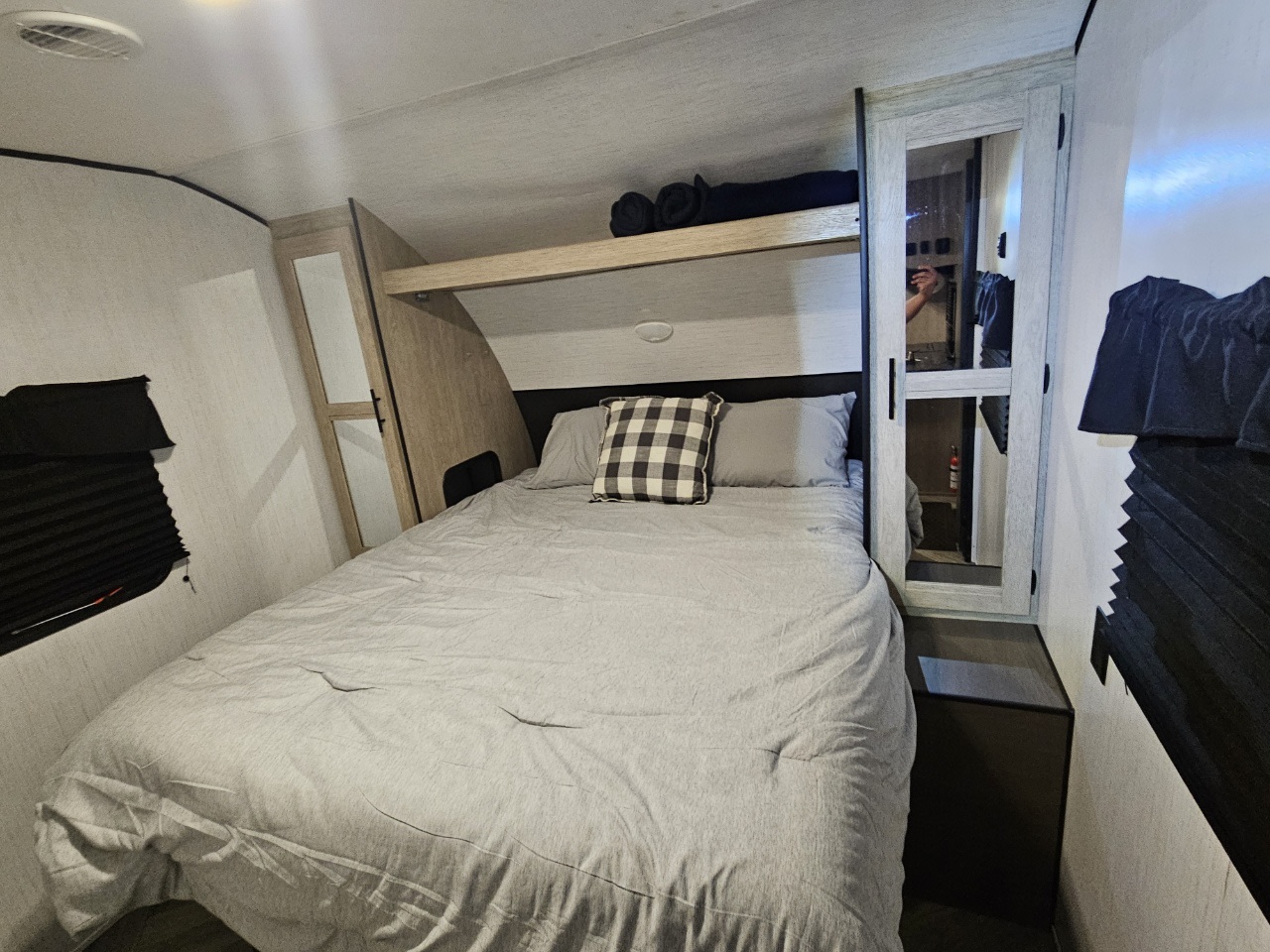 RV rental bedroom: a cozy space with a comfortable bed, overhead bunk, and mirrored wardrobe for travel convenience.. Heartland RVs Prowler 2022