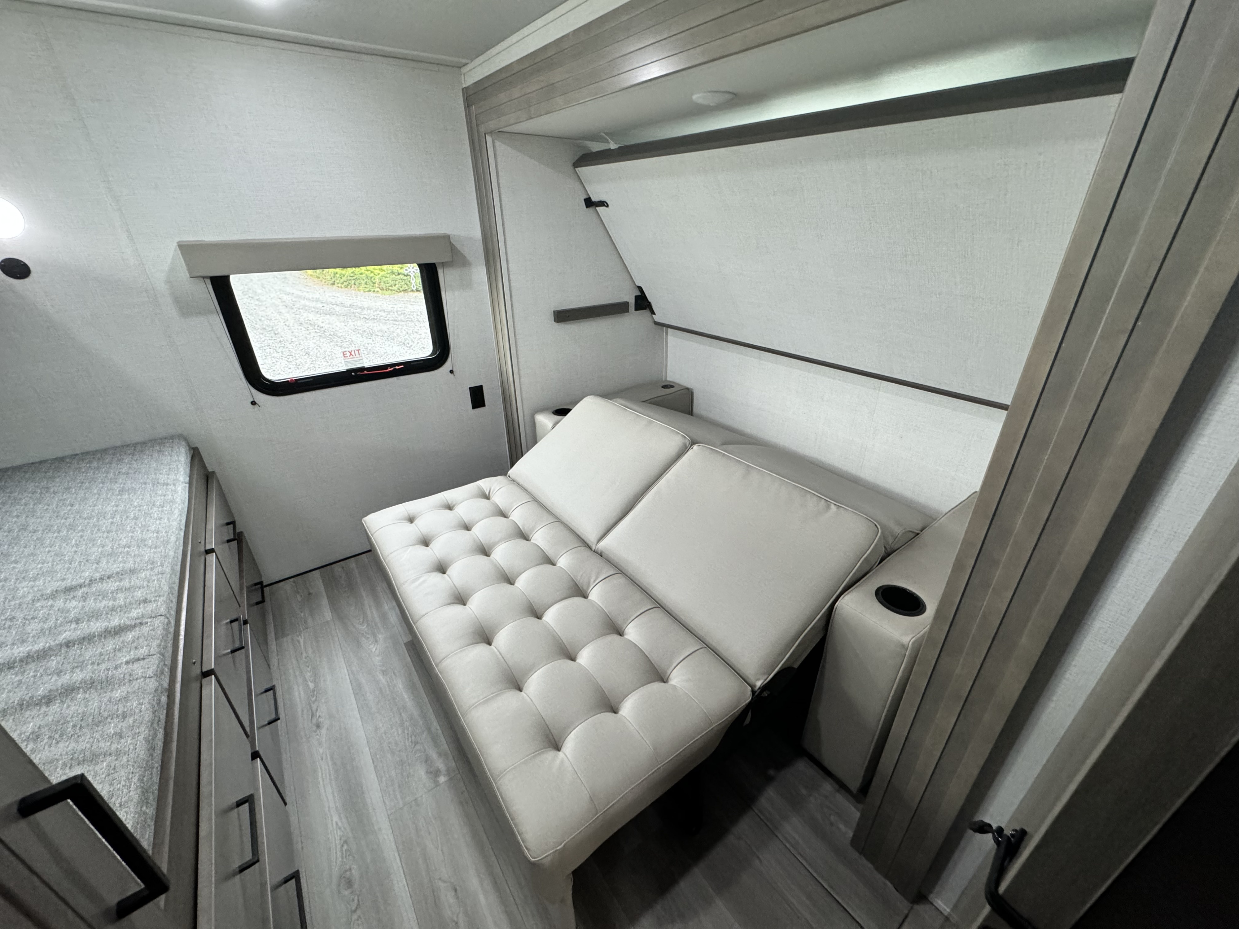 Compact RV rental interior featuring a convertible sofa bed and smart storage solutions.. Grand Design Transcend Xplor 2024