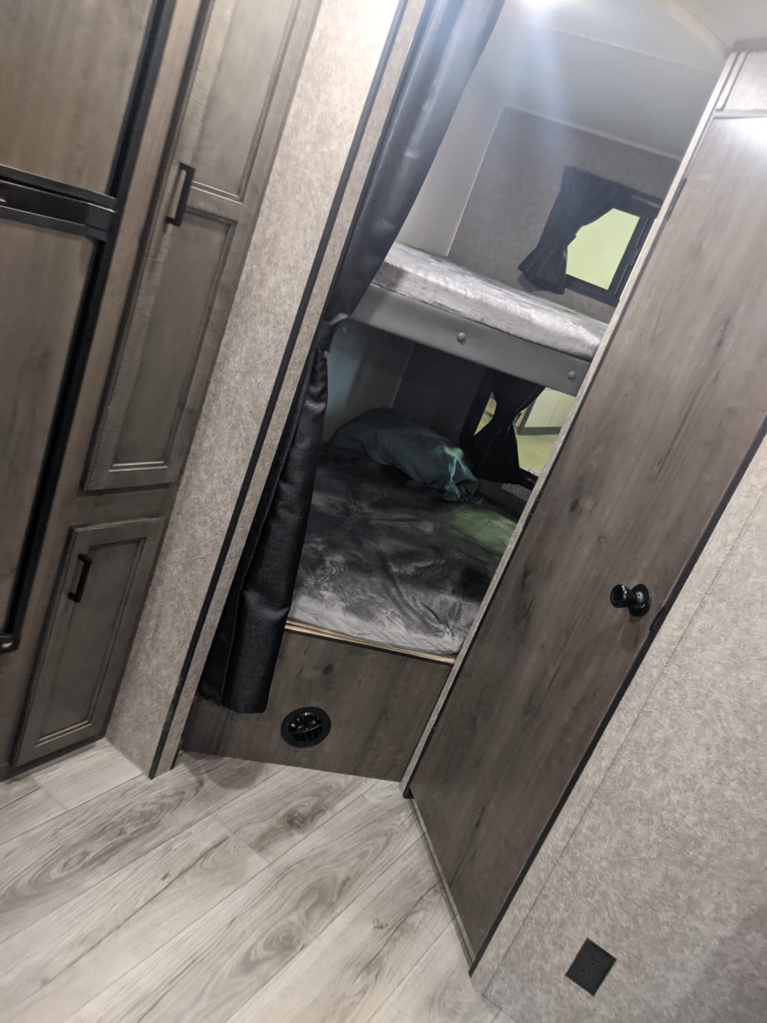 Inside this RV rental, bunk beds offer comfortable sleeping. Features include wood-look flooring, cabinets, and private curtains.. Starcraft Autumn Ridge 2021