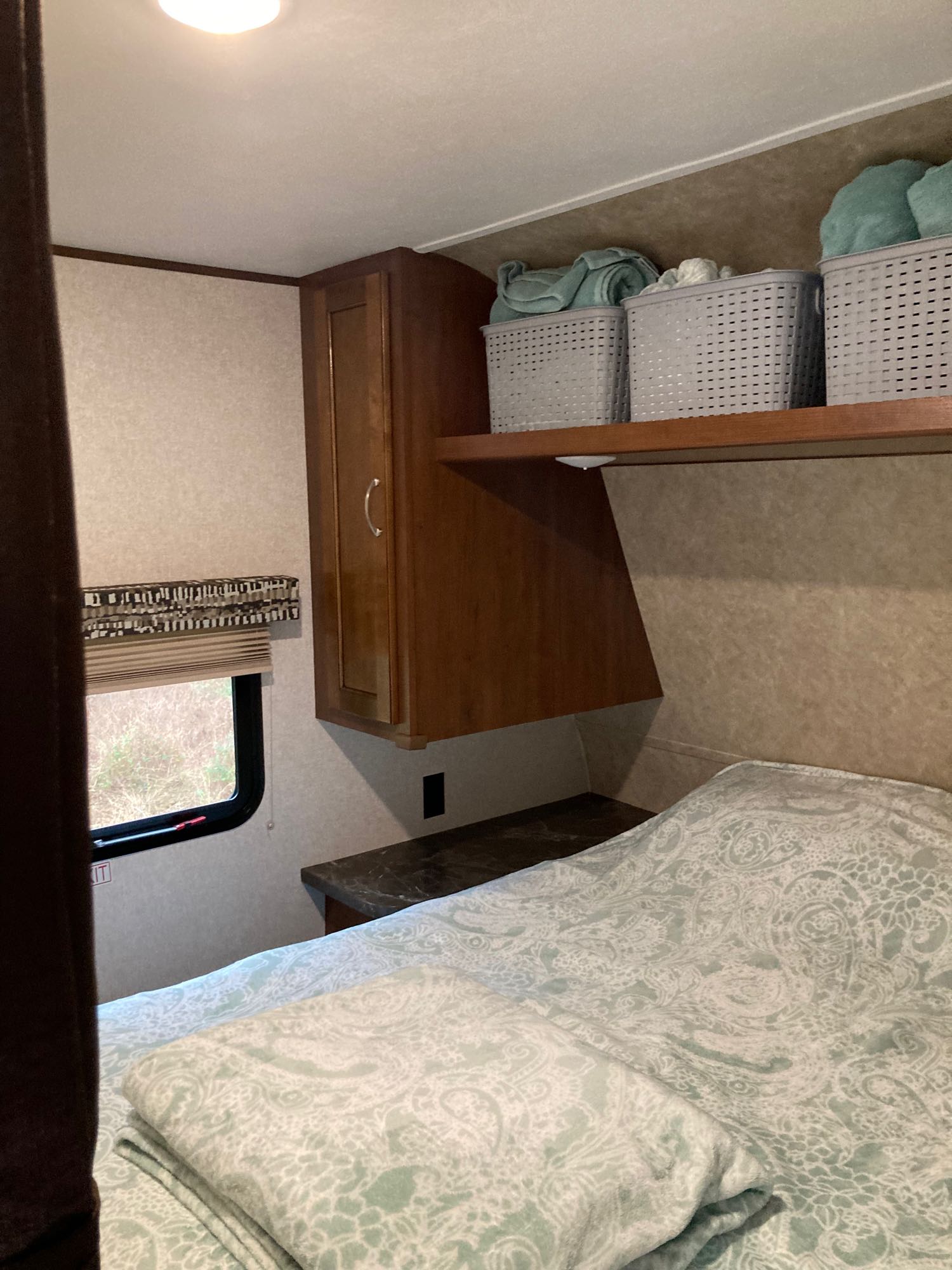 This RV rental bedroom features a comfy bed, window, and practical overhead storage with towels for guests.. Jayco Jay Flight SLX 2017