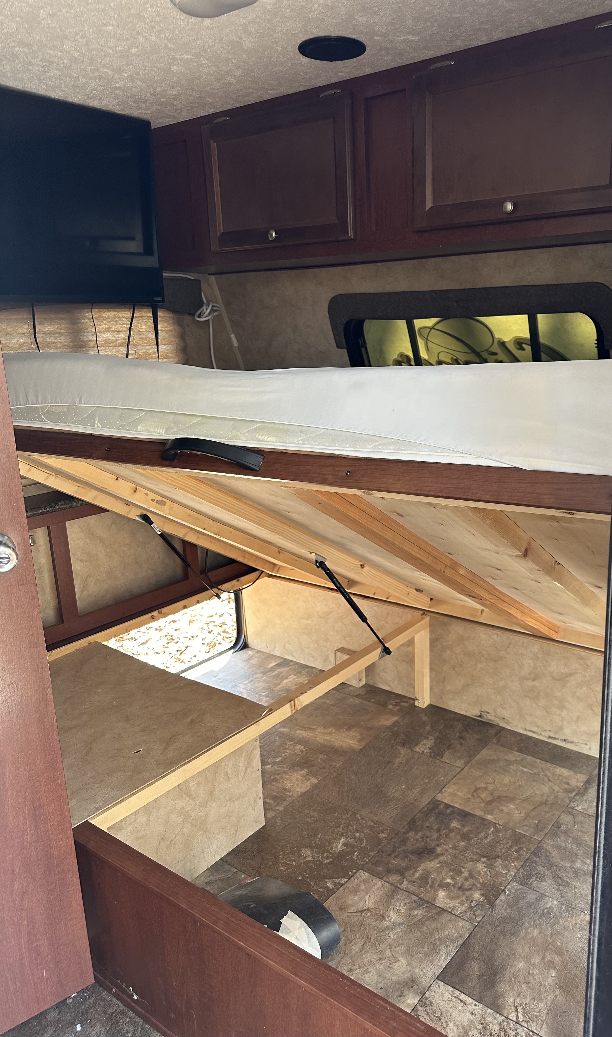 Explore this RV rental's clever bedroom. Lift-up bed reveals ample storage; overhead cabinets & TV included.. Clipper Clipper Trailer 2016