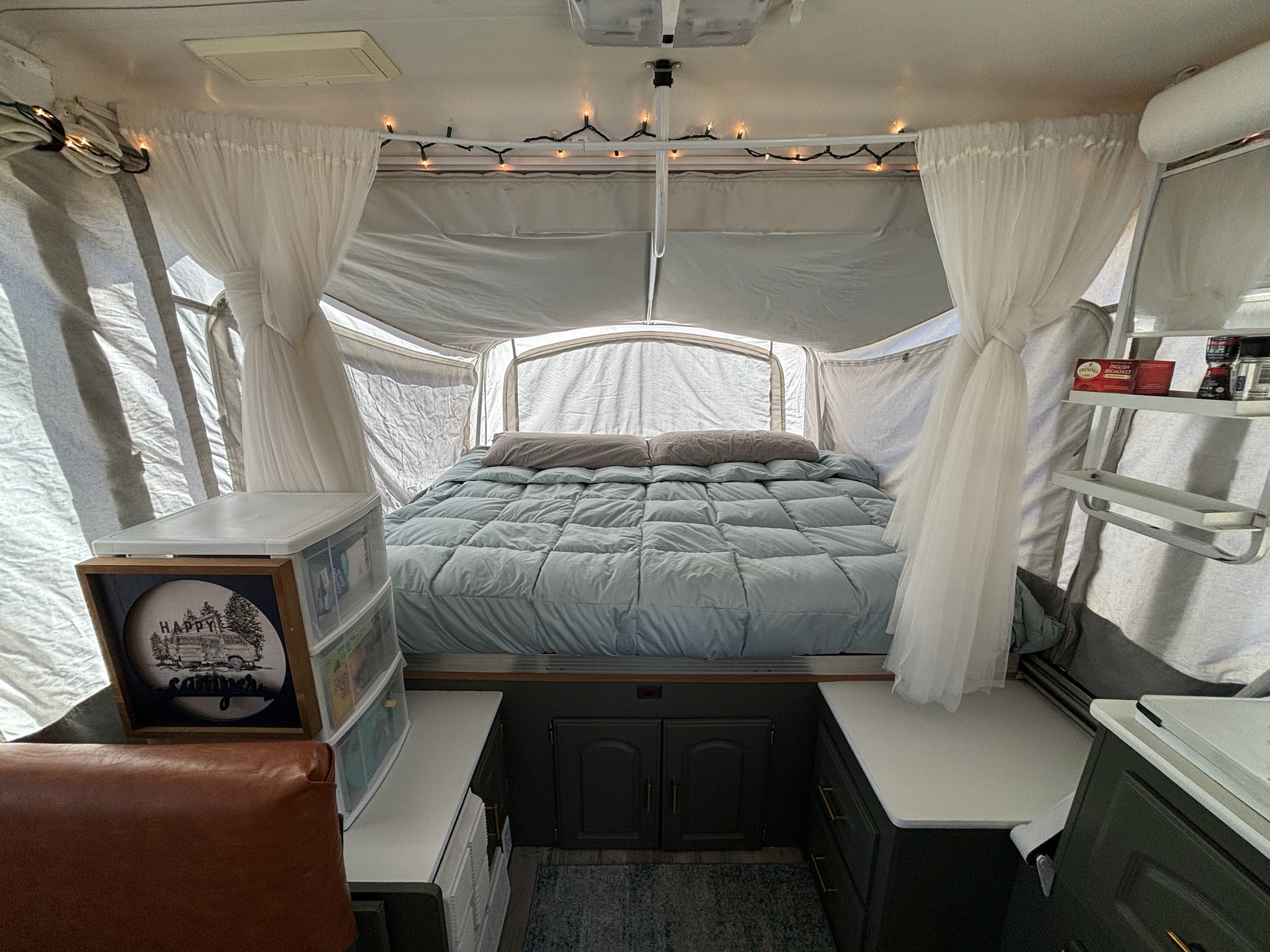 Step inside this cozy pop-up camper RV rental, featuring a comfortable bed, ambient lights, and smart storage.. Coleman Grand Tour Elite 2000