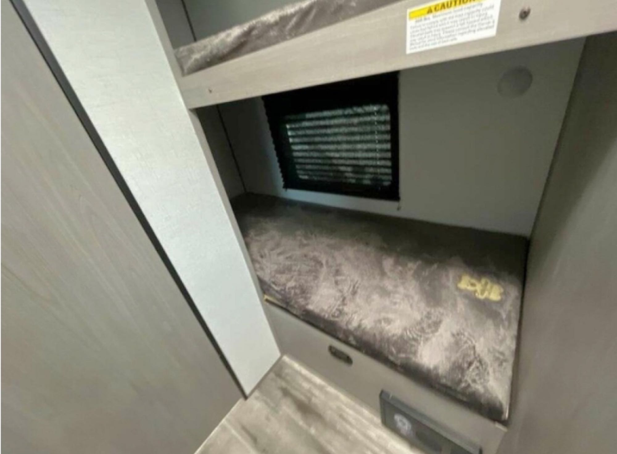 Inside an RV rental, this compact bunk bed features a plush lower mattress, window with blinds, and an upper bunk with safety warning.. Coleman Lantern 17b 2024