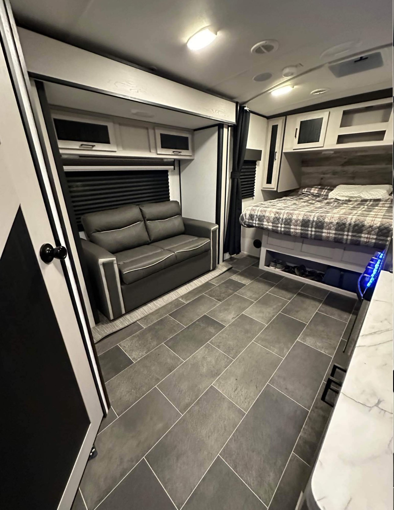 Spacious RV rental interior with modern sofa, bed, and stylish flooring. Ideal for comfortable travel.. Heartland RVs Mallard 2022