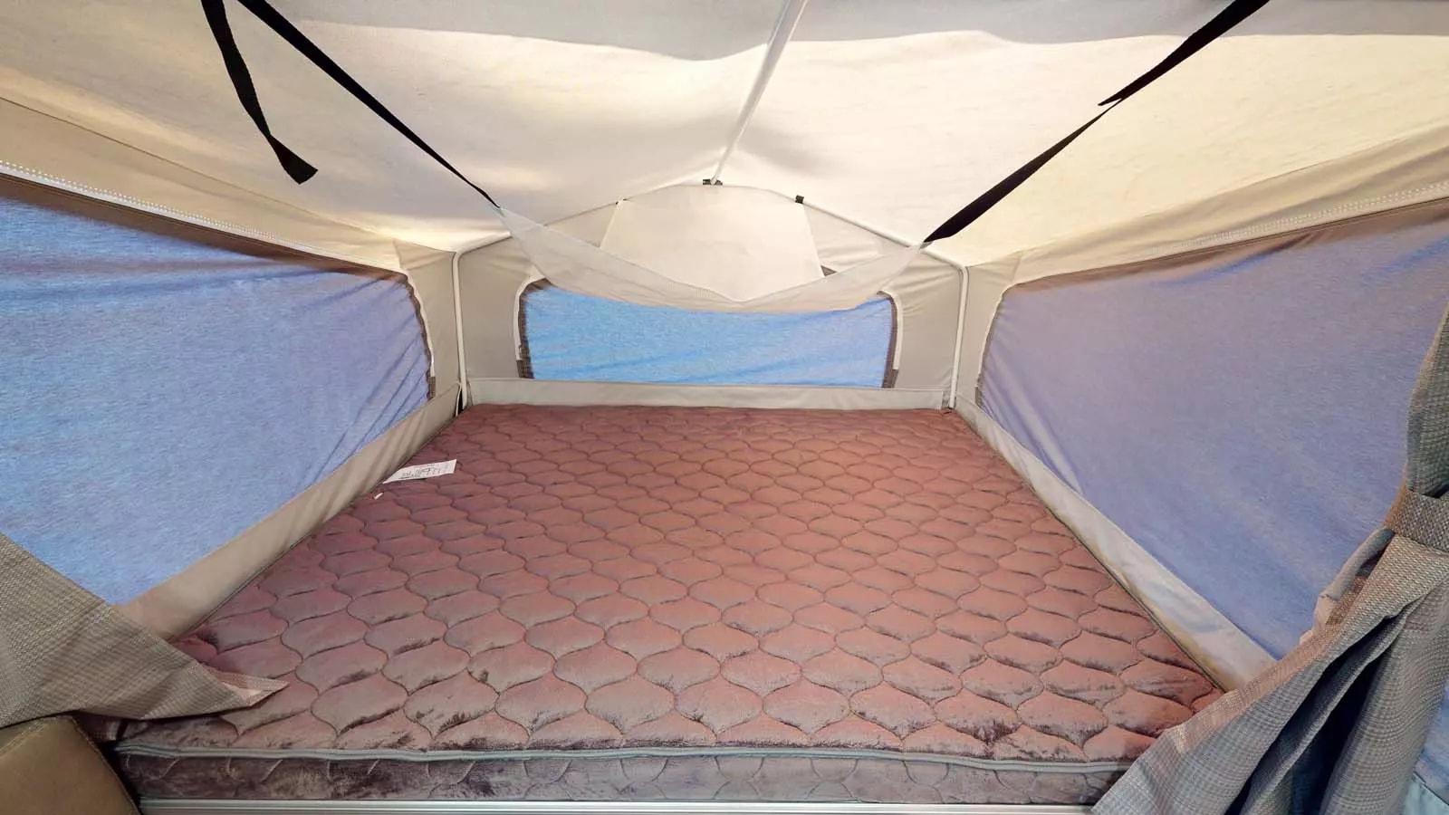 Inside an RV rental pop-up camper, showcasing the spacious bed. Perfect for camping trips.. Forest River Rockwood ESP 2023