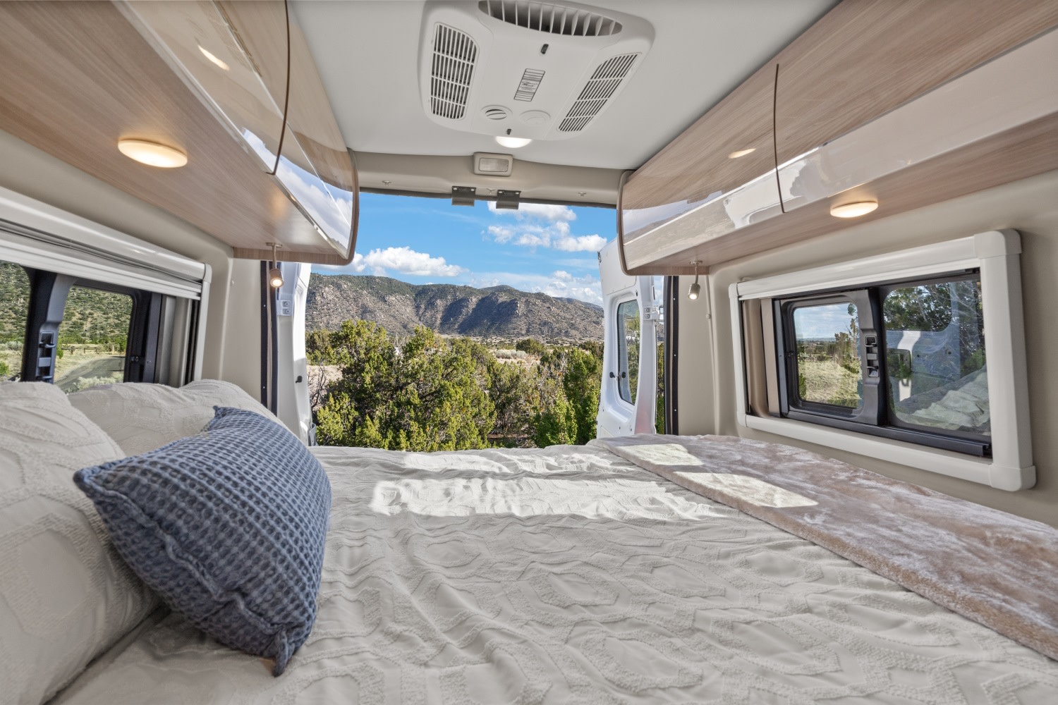 Cozy RV rental bedroom with panoramic mountain views from open back doors. Perfect for scenic travels!. Thor Sequence 2022