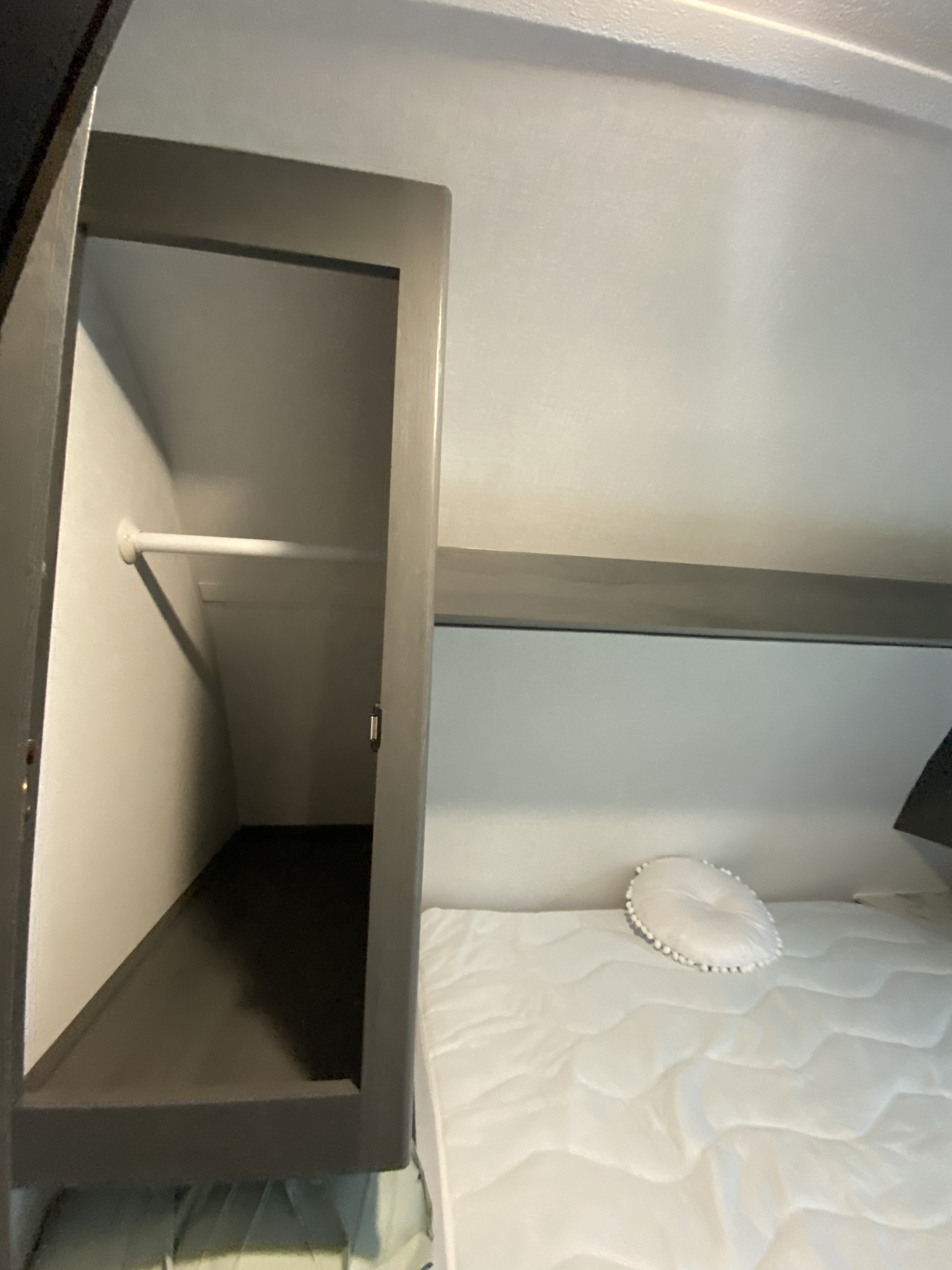 This RV rental features a cozy sleeping area with a white mattress & pillow, and a practical open closet.. Keystone RV Other 2024